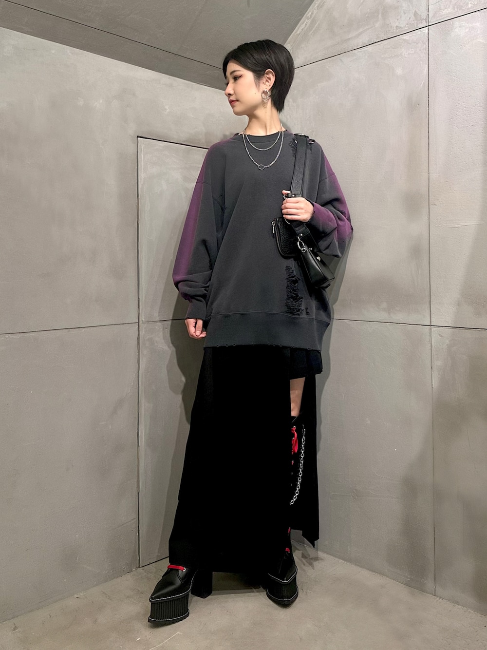 ブラック系のスウェット、ブラック系のスカート、ブラック系のブーツを着用したレディースの冬コーディネートの1枚目の写真