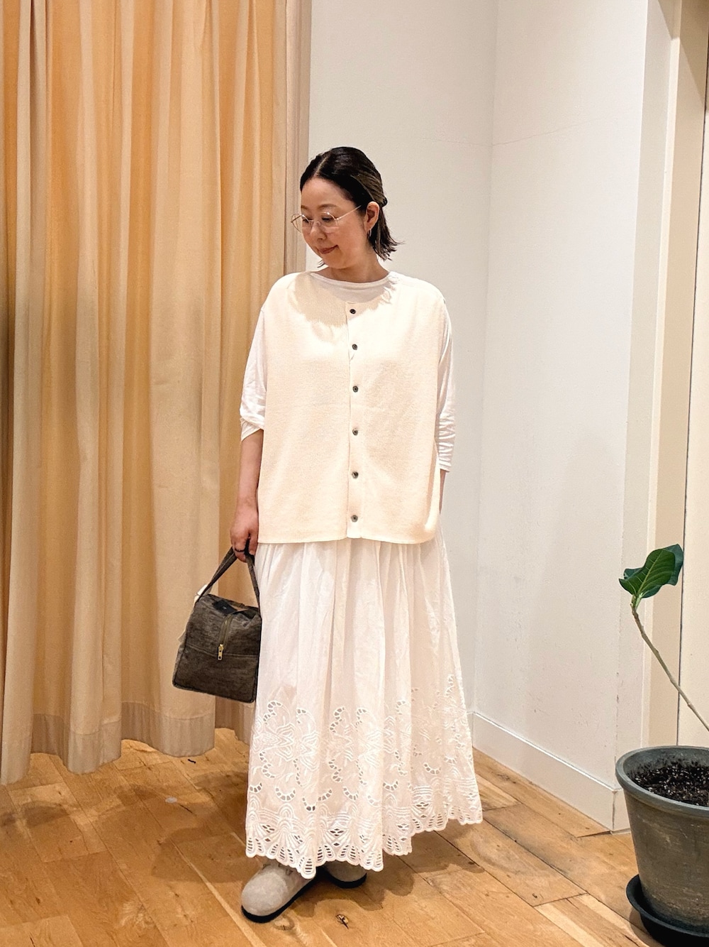 ホワイト系のスカート、ホワイト系のTシャツ/カットソー、ホワイト系のベストを着用したレディースの秋コーディネートの1枚目の写真