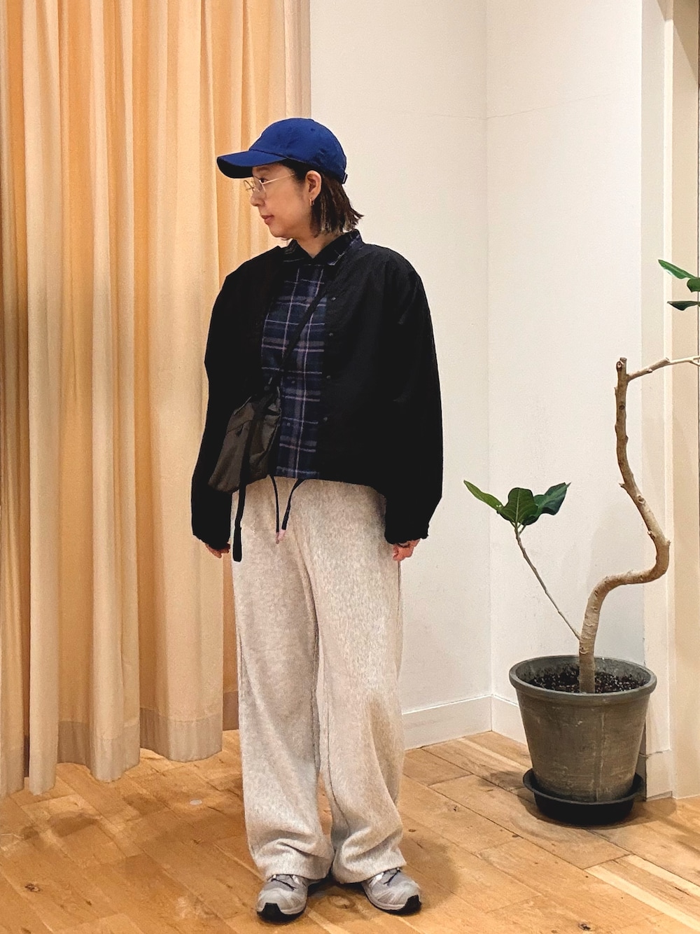グレー系のその他パンツ、グレー系のスニーカー、ブラウン系のショルダーバッグを着用したレディースの秋コーディネートの1枚目の写真