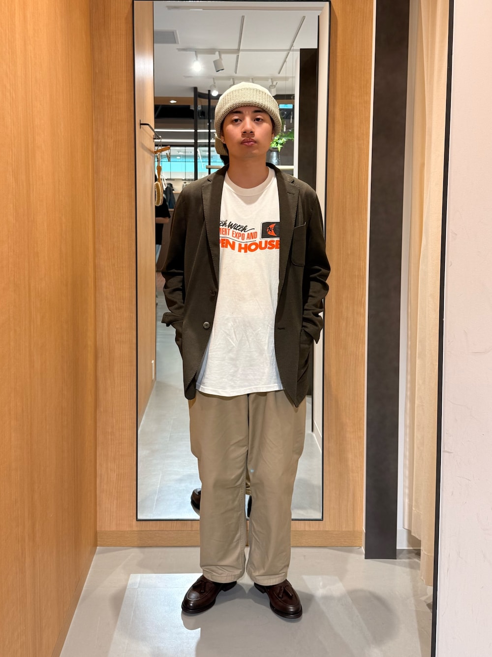 グリーン系のその他アウター、ブラウン系のドレスシューズ、ベージュ系のニットキャップ/ビーニーを着用したメンズの春コーディネートの1枚目の写真