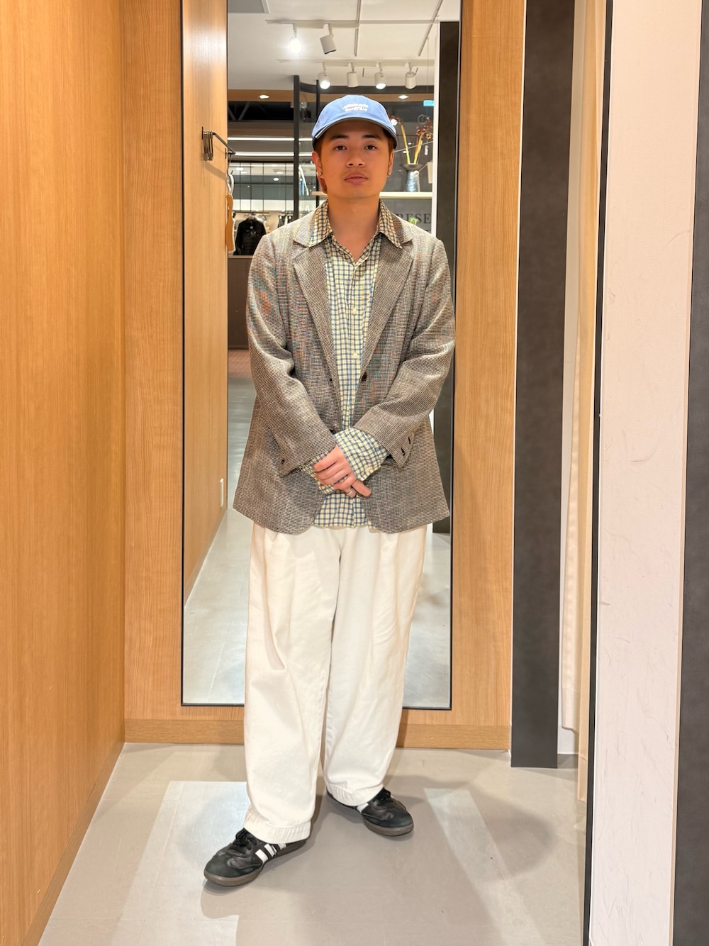グレー系のその他アウター、ブルー系のキャップを着用したメンズの秋コーディネートの1枚目の写真