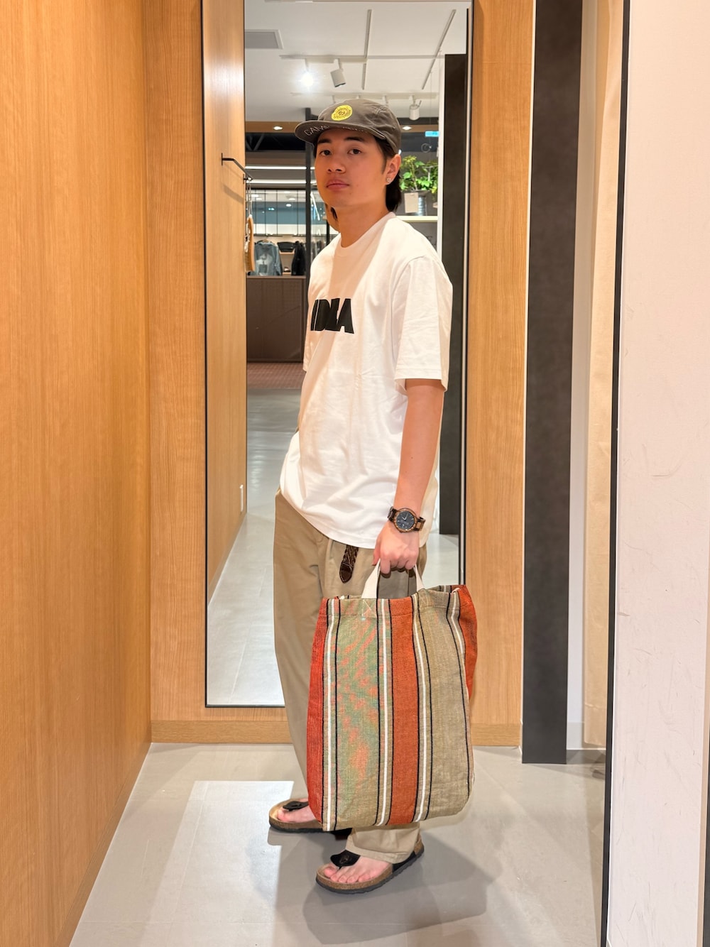 ホワイト系のTシャツ/カットソー、オレンジ系のトートバッグを着用したメンズの夏コーディネートの1枚目の写真