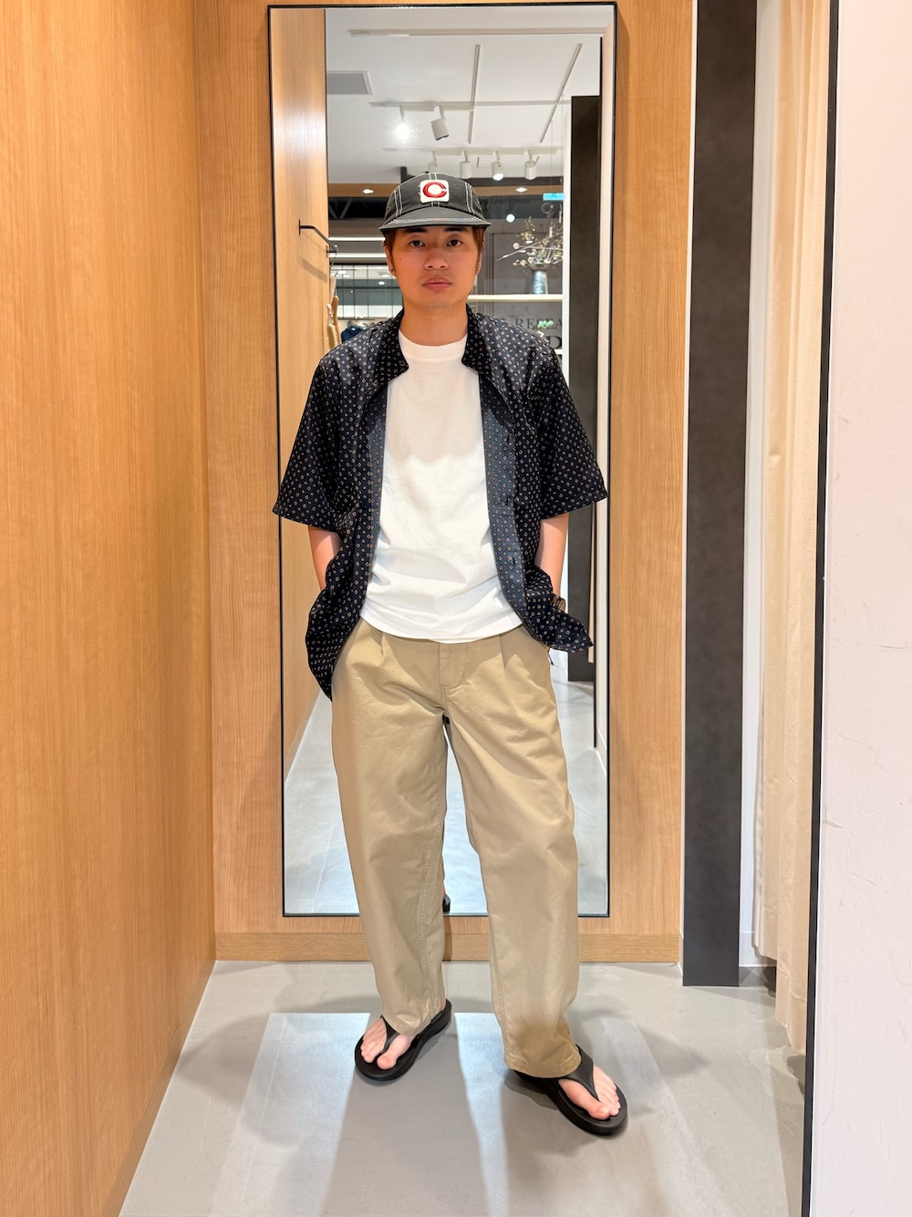 ベージュ系のその他パンツ、ブラック系のサンダル、ホワイト系のTシャツ/カットソーを着用したメンズの春コーディネートの1枚目の写真