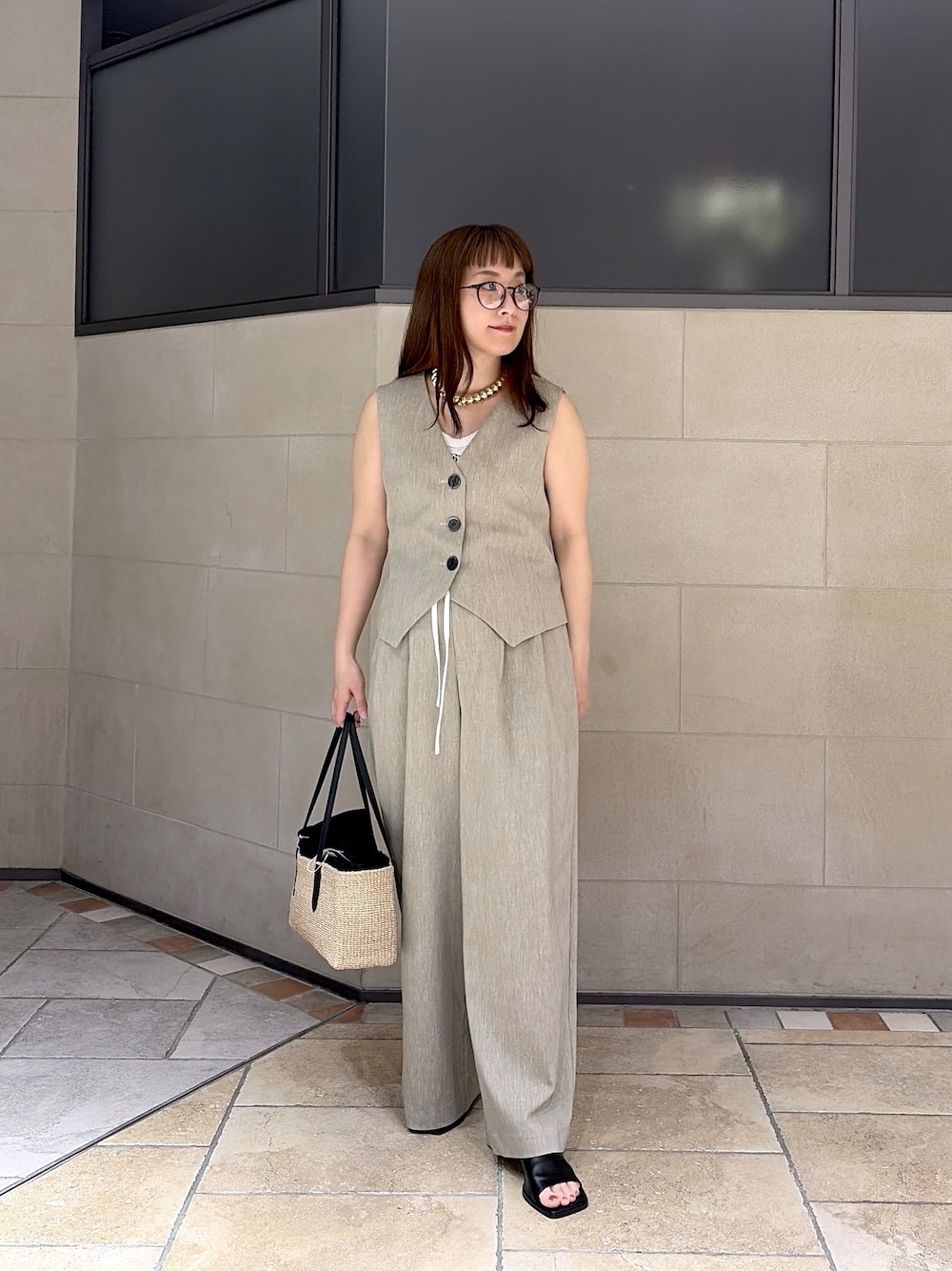 ベージュ系のベスト、ホワイト系のタンクトップ、ベージュ系のその他パンツを着用したレディースの春コーディネートの1枚目の写真