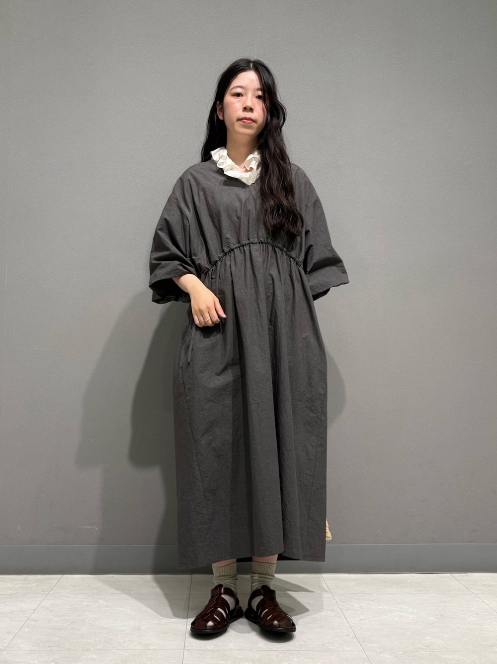 ベージュ系のショルダーバッグ、ホワイト系のシャツ/ブラウス、シルバー系のネックレスを着用したレディースの春コーディネートの1枚目の写真