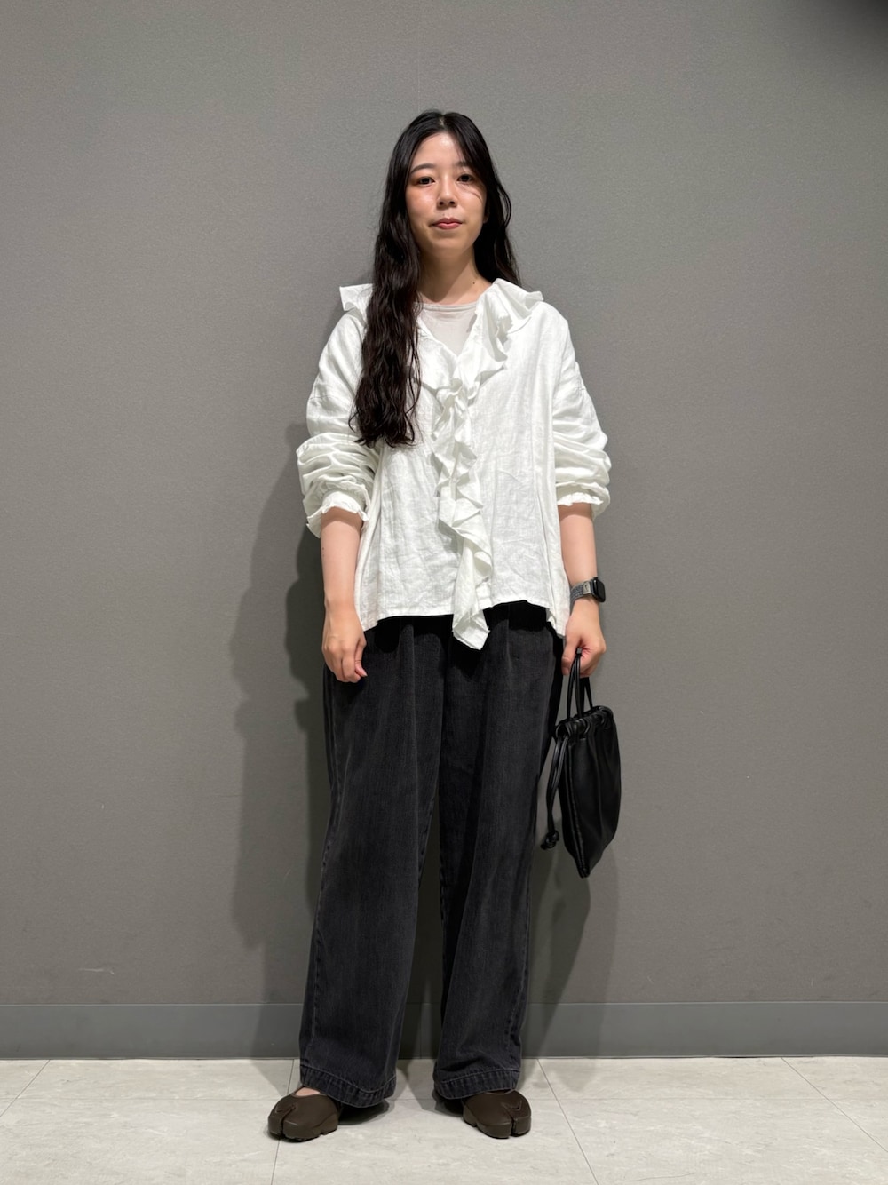 ホワイト系のシャツ/ブラウス、ブラック系のデニムパンツ、ブラウン系のスニーカーを着用したレディースの夏コーディネートの1枚目の写真