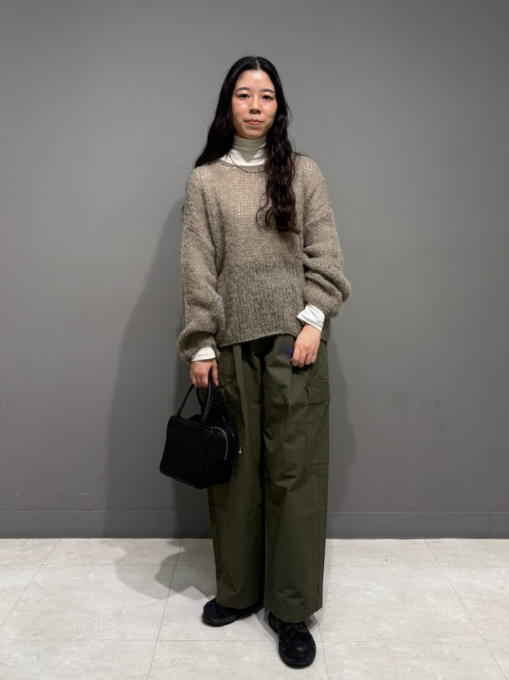 グレー系のニット/セーター、ホワイト系のTシャツ/カットソー、グリーン系のその他パンツを着用したレディースの秋コーディネートの1枚目の写真