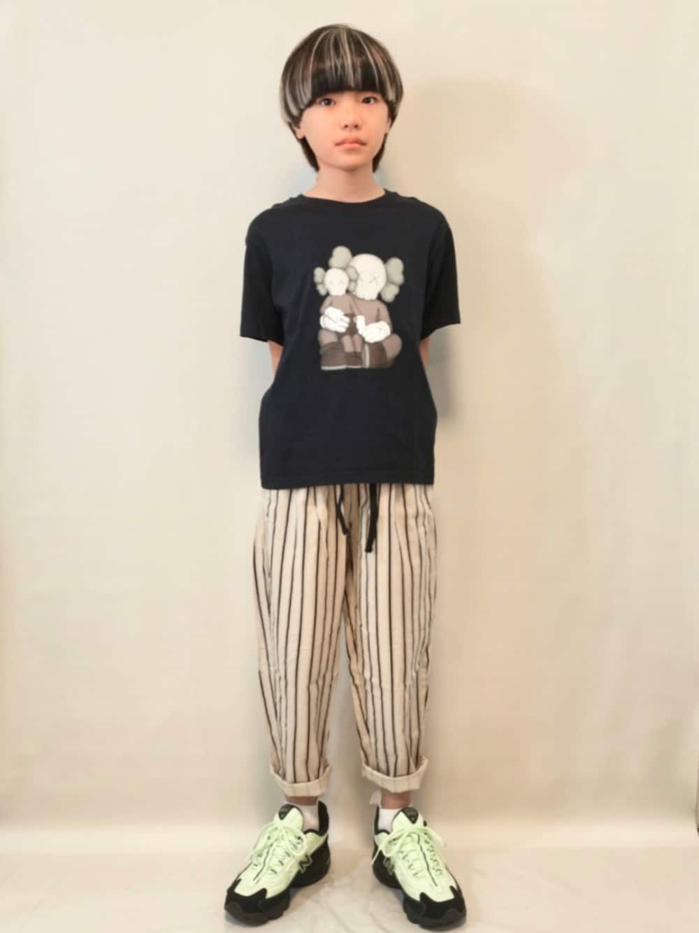 グリーン系のスニーカー、ベージュ系のその他パンツ、ブラック系のTシャツ/カットソーを着用したキッズの秋コーディネートの1枚目の写真