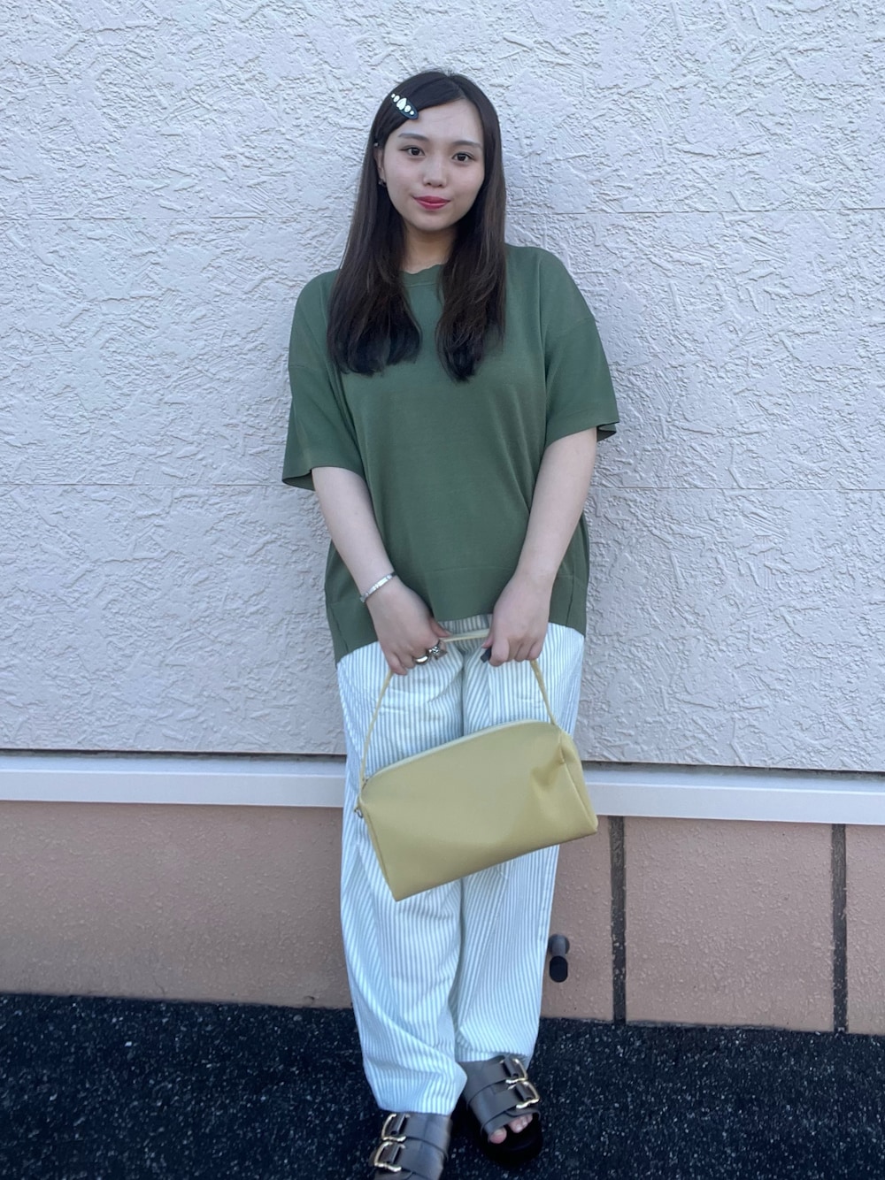 グリーン系のニット/セーター、ブルー系のその他パンツ、ブラック系のバレッタ/ヘアクリップを着用したレディースの夏コーディネートの1枚目の写真