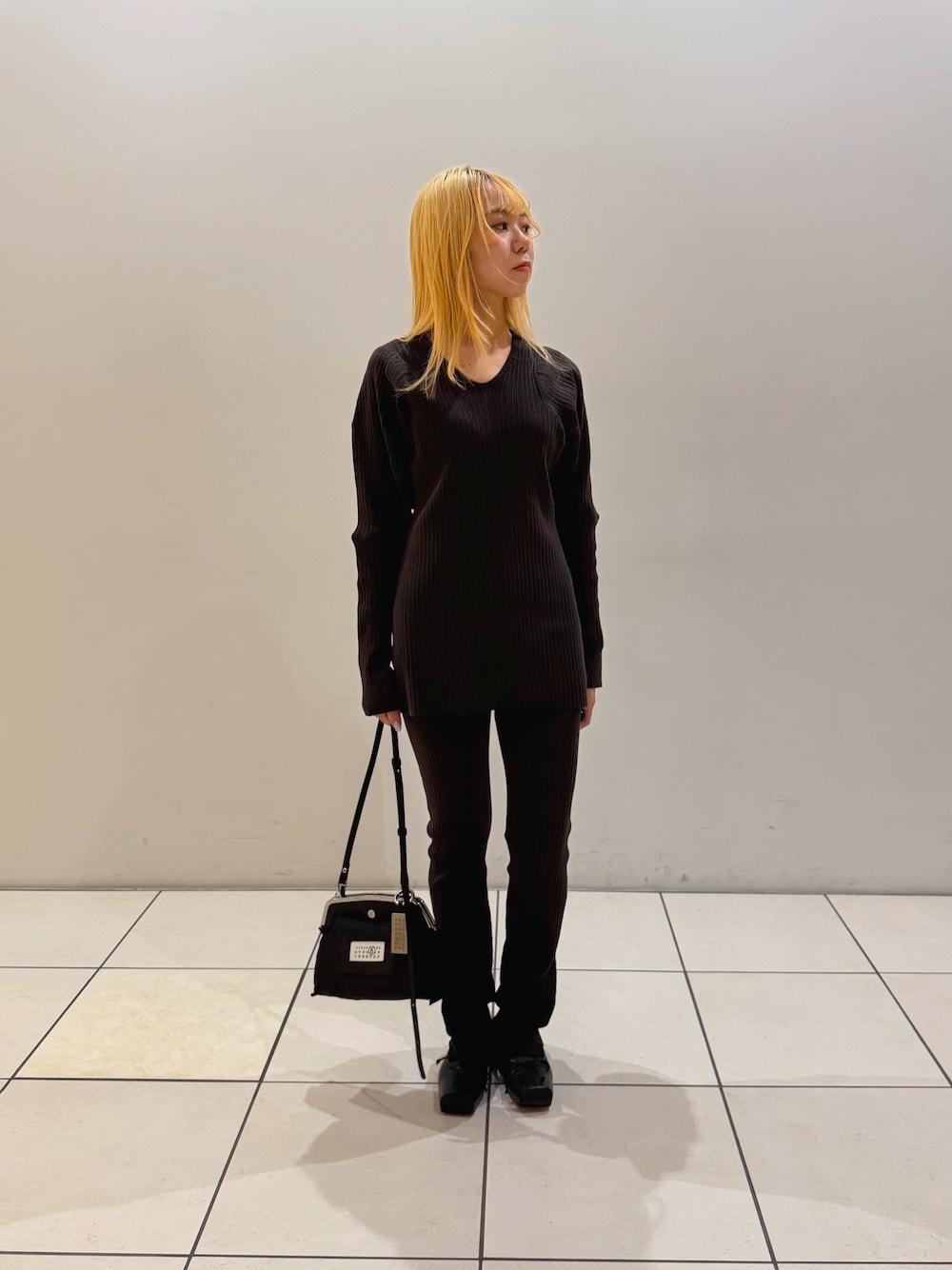ブラウン系のニット/セーター、ブラウン系のその他パンツ、ブラック系のショルダーバッグを着用したレディースの秋コーディネートの1枚目の写真