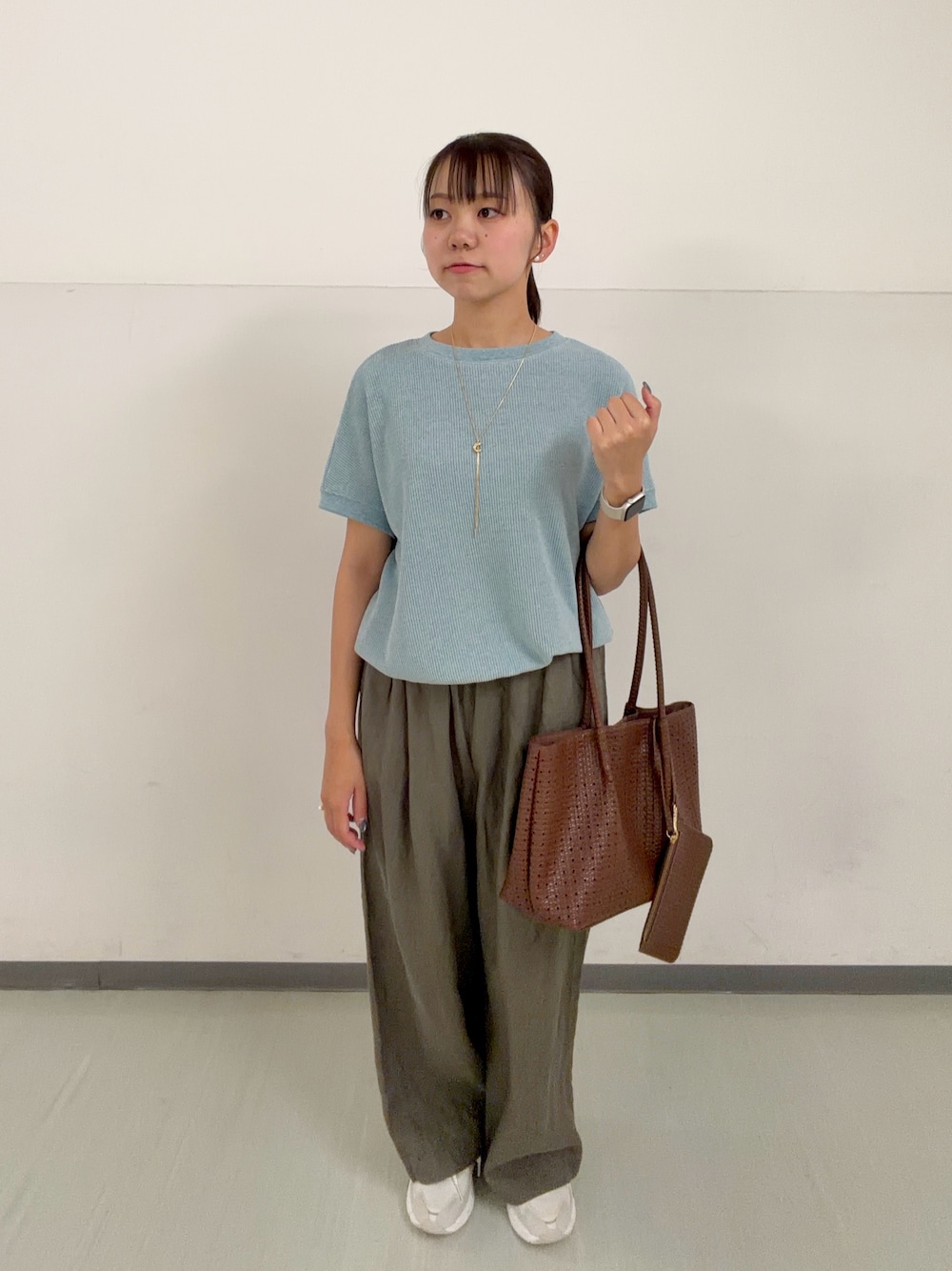 ブラウン系のトートバッグ、ブルー系のTシャツ/カットソー、ホワイト系のスニーカーを着用したレディースの春コーディネートの1枚目の写真