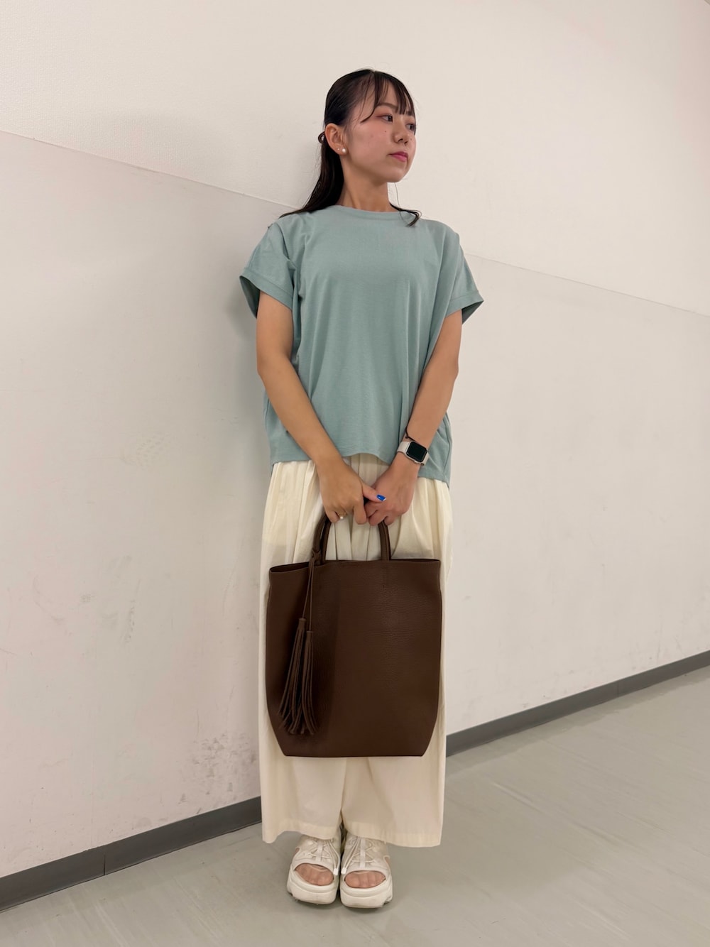 グリーン系のTシャツ/カットソー、ホワイト系のその他パンツ、ブラウン系のトートバッグを着用したレディースの夏コーディネートの1枚目の写真