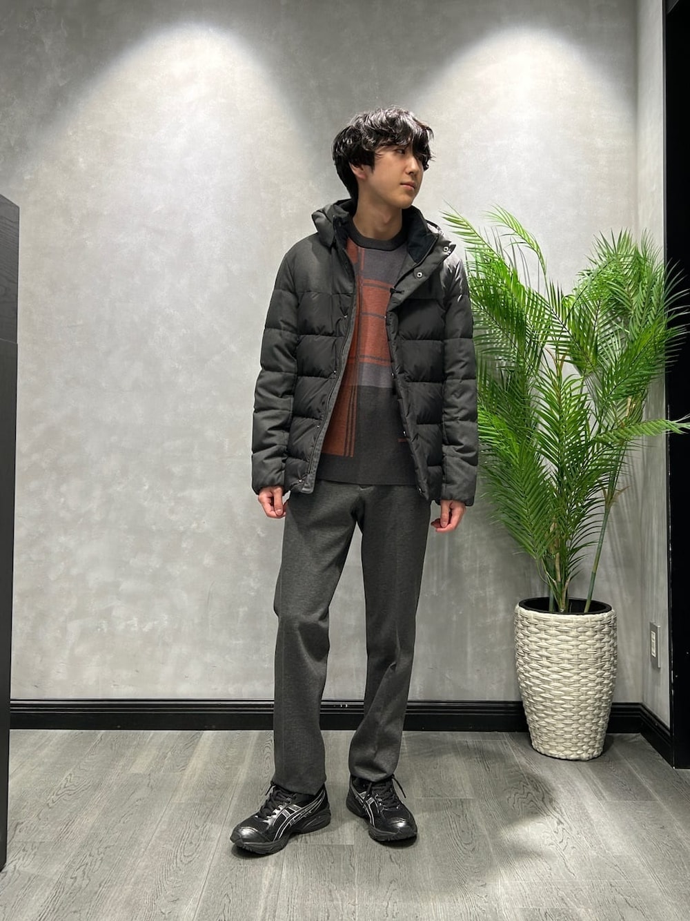 ブラック系のダウンジャケット/コート、グレー系のニット/セーター、ブラック系のスラックスを着用したメンズの冬コーディネートの1枚目の写真