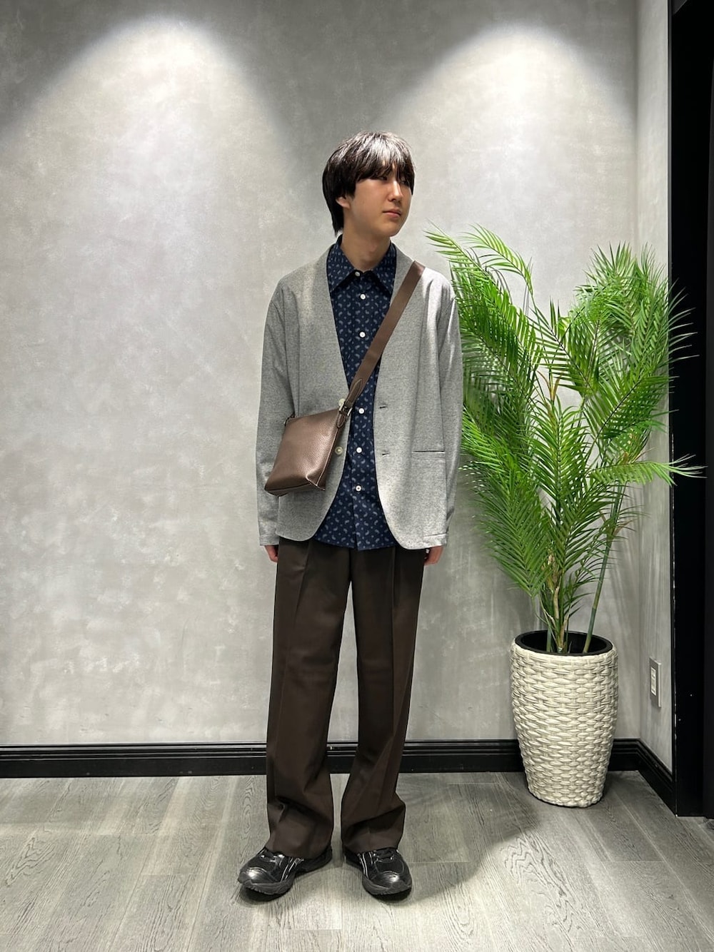 グレー系のカーディガン/ボレロ、ブルー系のシャツ/ブラウス、ブラウン系のスラックスを着用したメンズの春コーディネートの1枚目の写真