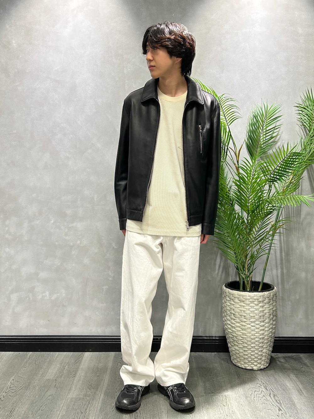 ブラック系のブルゾン、ホワイト系のTシャツ/カットソー、ホワイト系のデニムパンツを着用したメンズの秋コーディネートの1枚目の写真