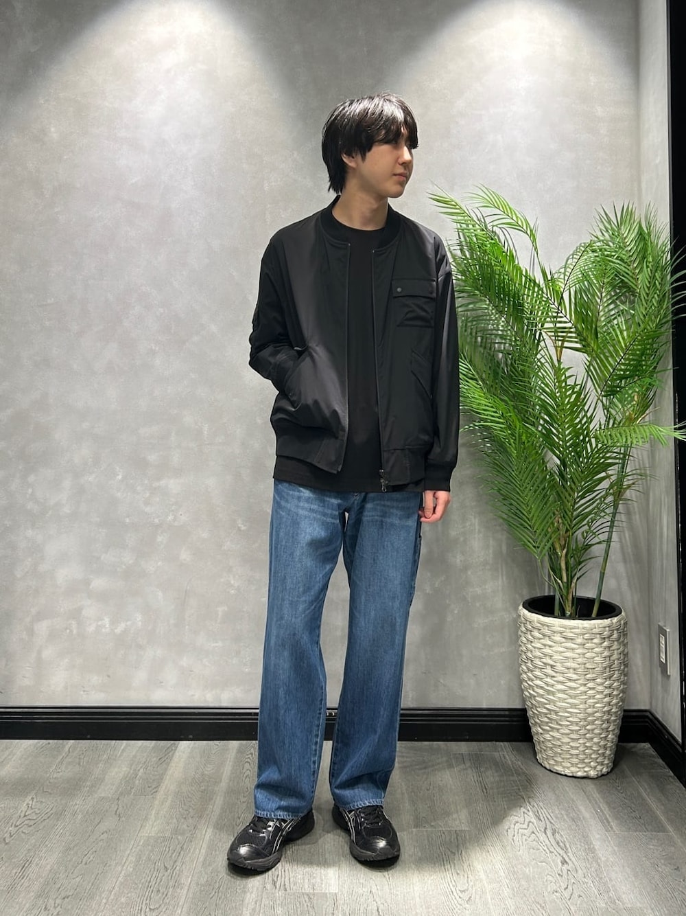 ブラック系のブルゾン、ブラック系のTシャツ/カットソー、ブルー系のデニムパンツを着用したメンズの春コーディネートの1枚目の写真