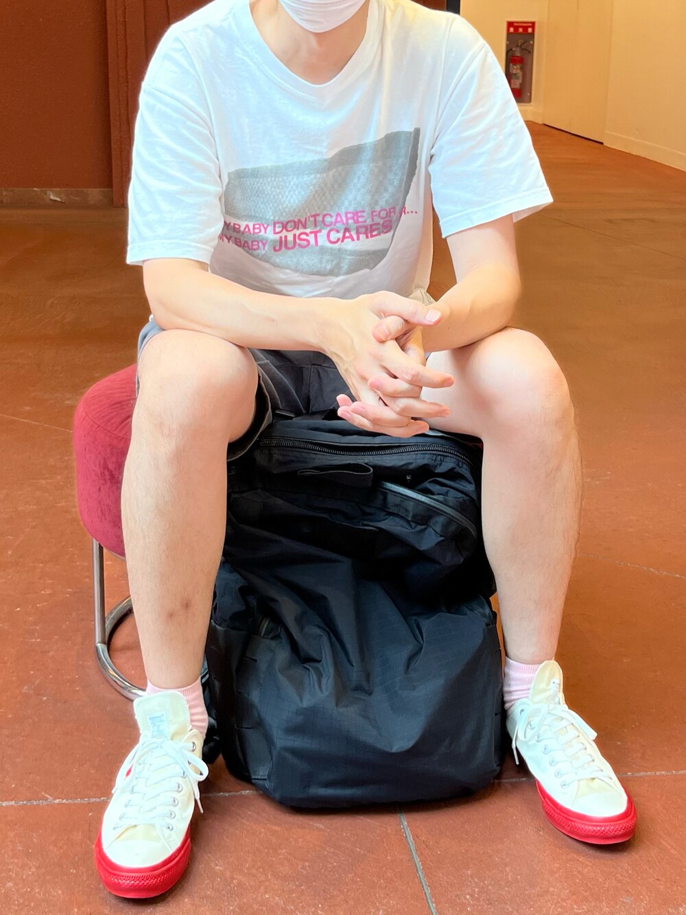 ホワイト系のTシャツ/カットソー、グレー系のチノパンツ、ブラック系のバックパック/リュックを着用したメンズの夏コーディネートの1枚目の写真