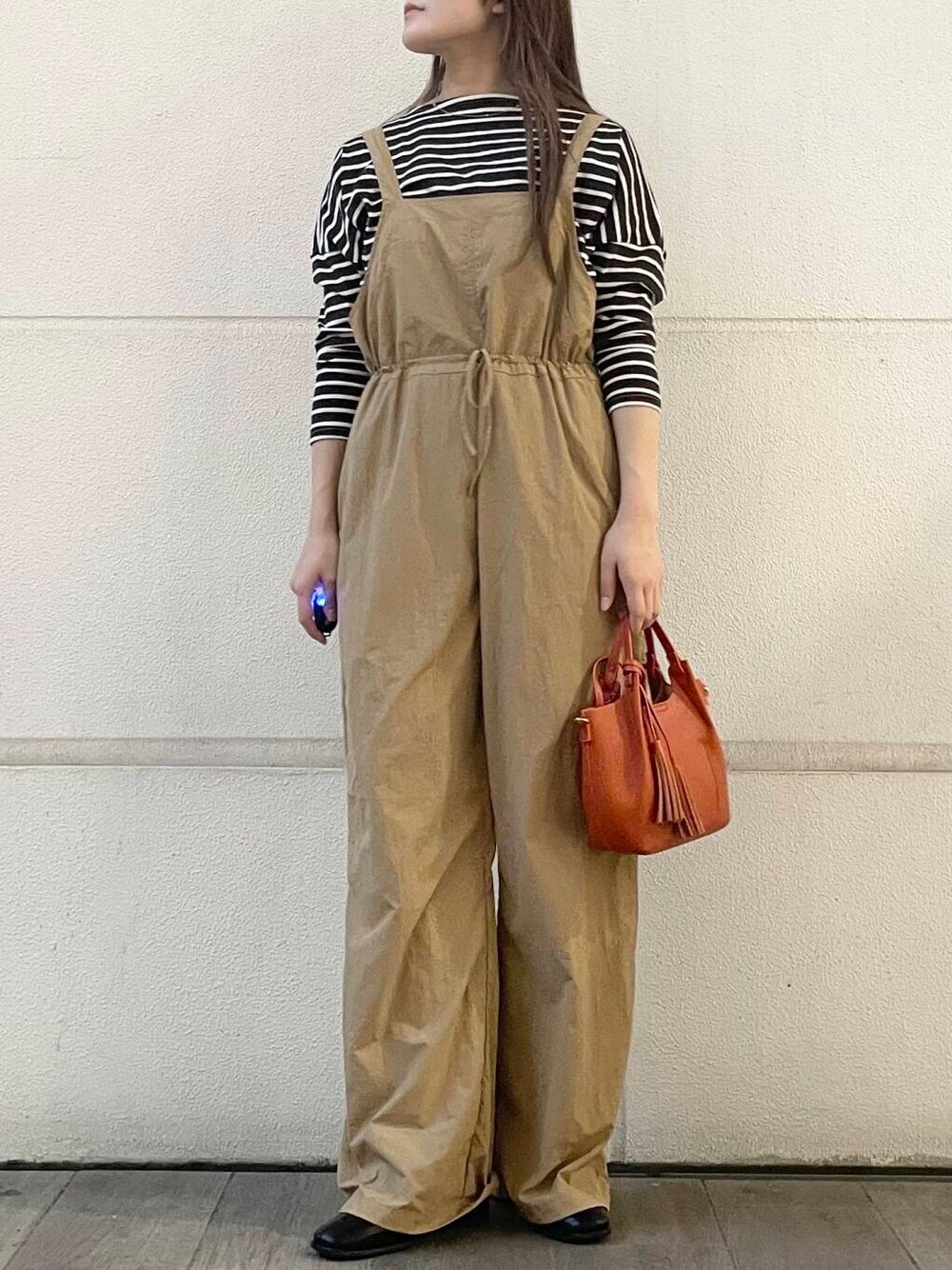 ベージュ系のサロペット/オーバーオール、ブラウン系のTシャツ/カットソーを着用したレディースの秋コーディネートの1枚目の写真