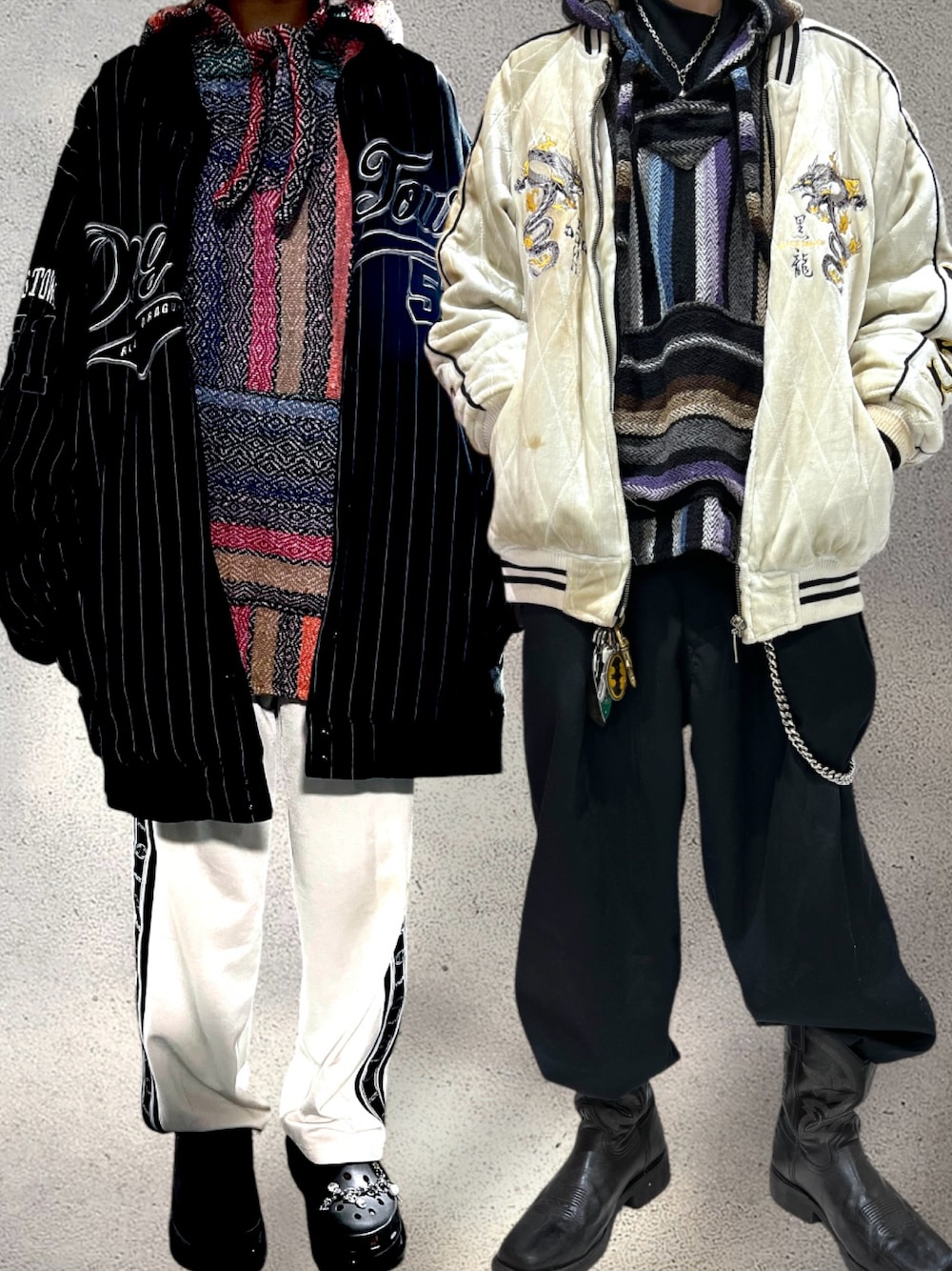 ホワイト系のスカジャン、ブラック系のパーカー、ブラック系のブーツを着用したメンズの冬コーディネートの1枚目の写真