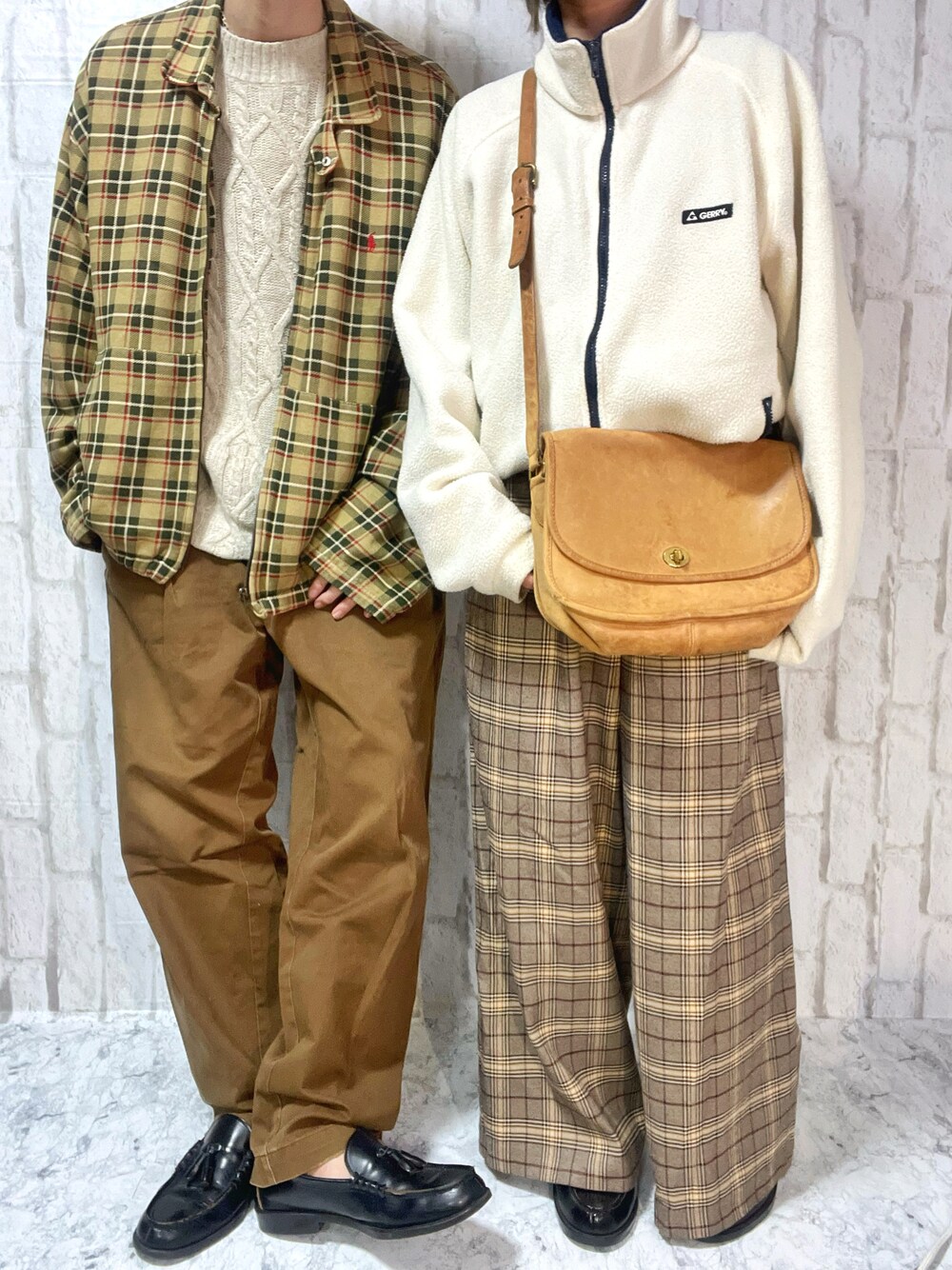 ブラウン系のショルダーバッグ、ブラウン系のチノパンツ、ブラック系のローファーを着用したメンズの春コーディネートの1枚目の写真