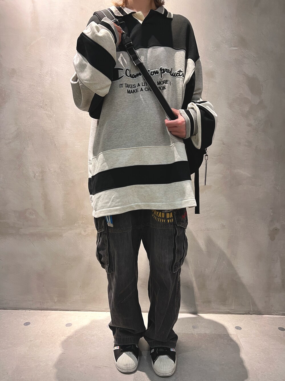 グレー系のスウェット、ブラック系のショルダーバッグ、グレー系のカーゴパンツを着用したメンズの春コーディネートの1枚目の写真