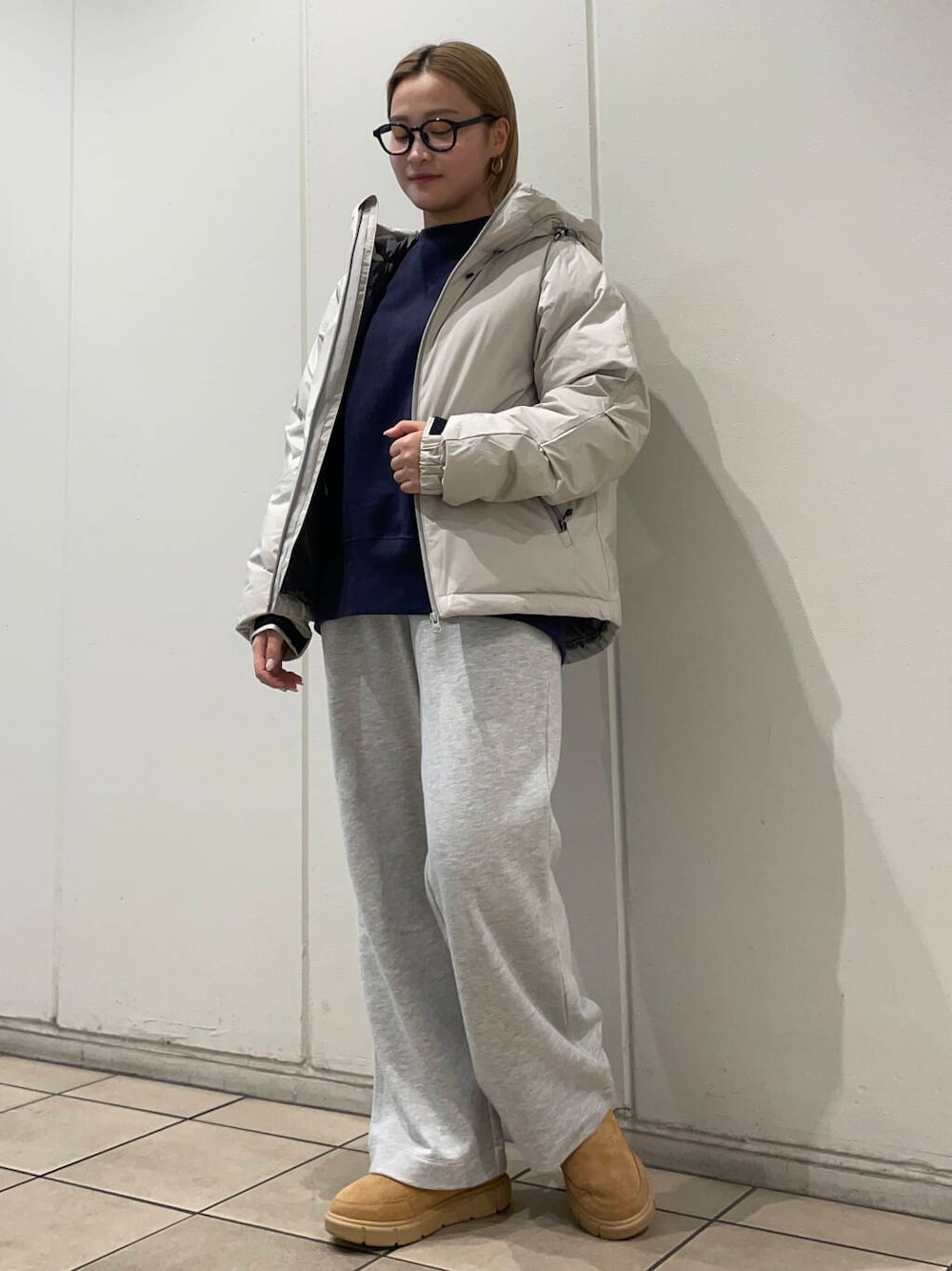 ホワイト系のダウンジャケット/コート、ブルー系のスウェット、グレー系のその他パンツを着用したレディースの秋コーディネートの1枚目の写真