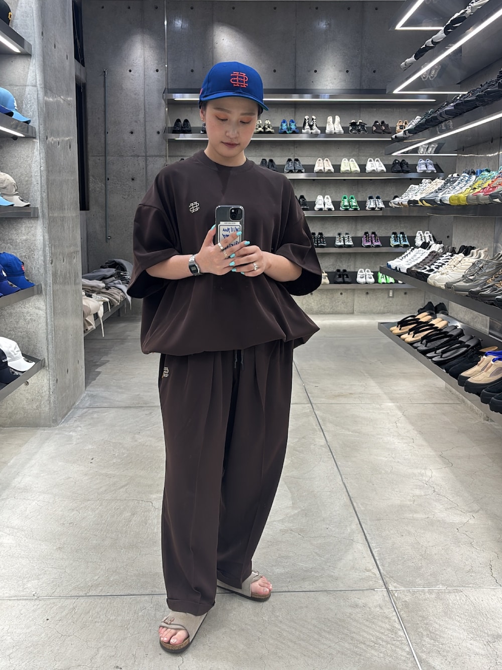 ブラウン系のTシャツ/カットソー、ブラウン系のその他パンツ、ブルー系のキャップを着用したレディースの夏コーディネートの1枚目の写真