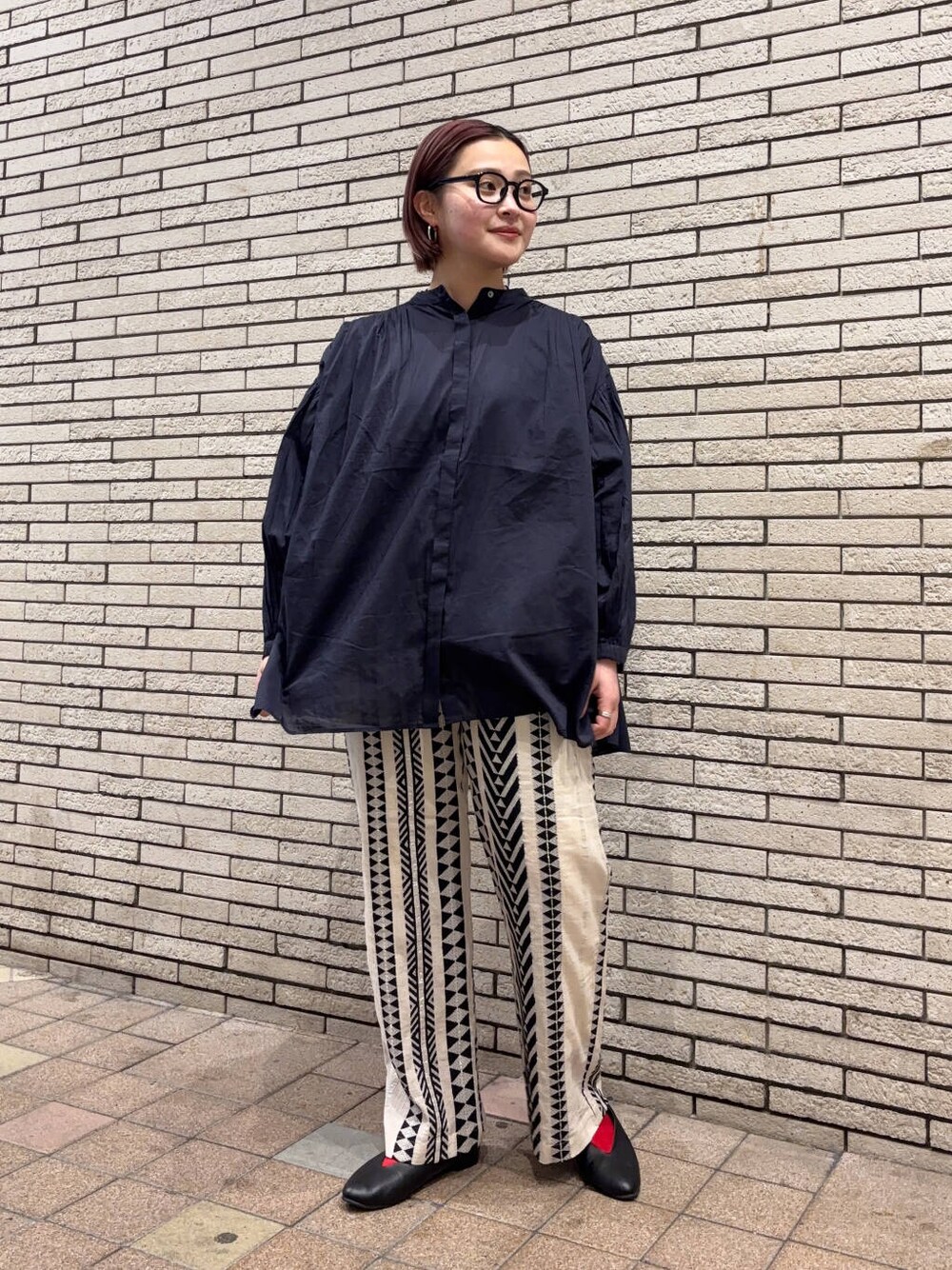 ブラック系のパンプス、ベージュ系のその他パンツ、ブルー系のシャツ/ブラウスを着用したレディースの春コーディネートの1枚目の写真