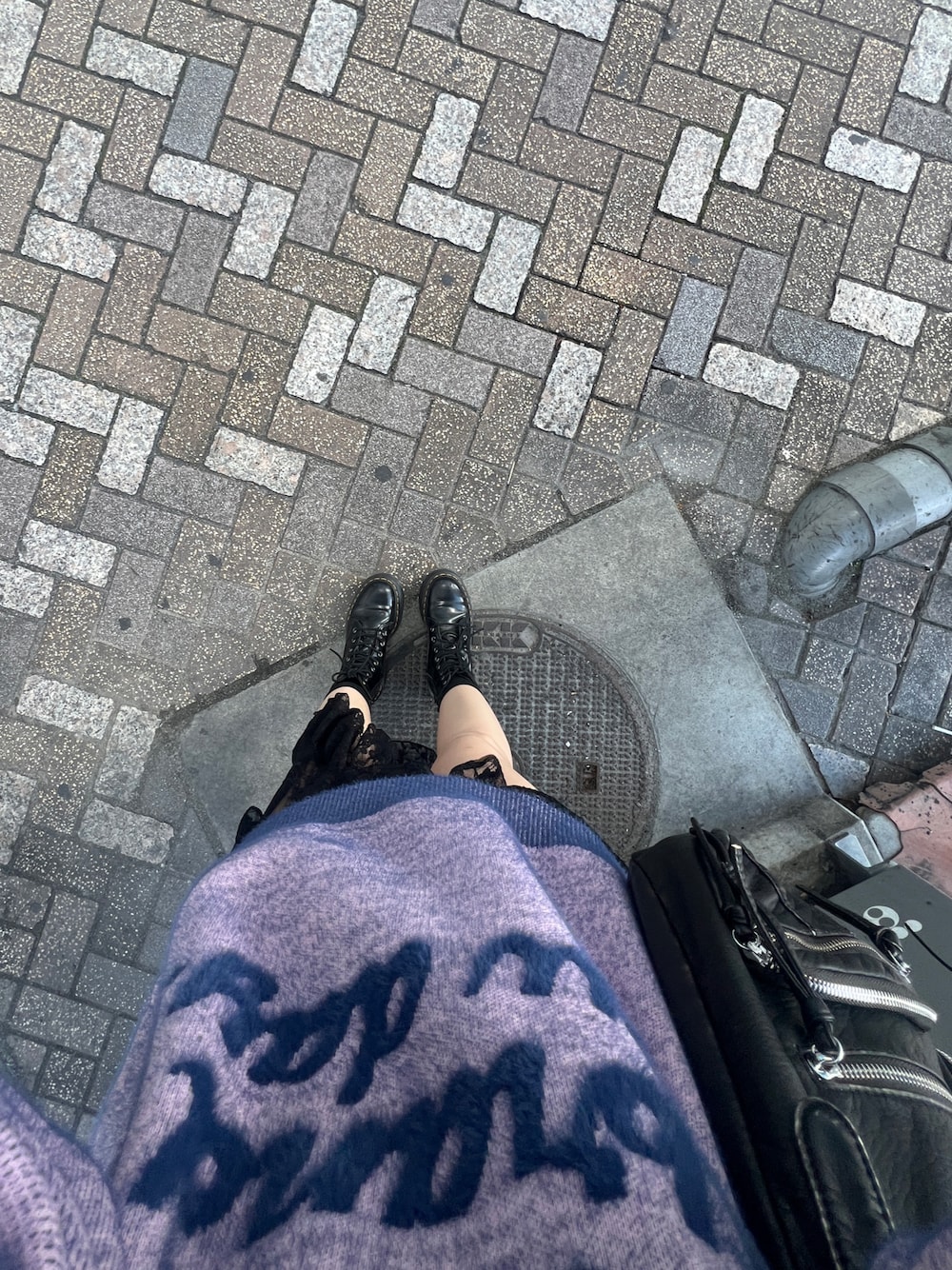 ブラック系のブーツ、ブラック系のスカート、ピンク系のニット/セーターを着用したレディースの秋コーディネートの1枚目の写真