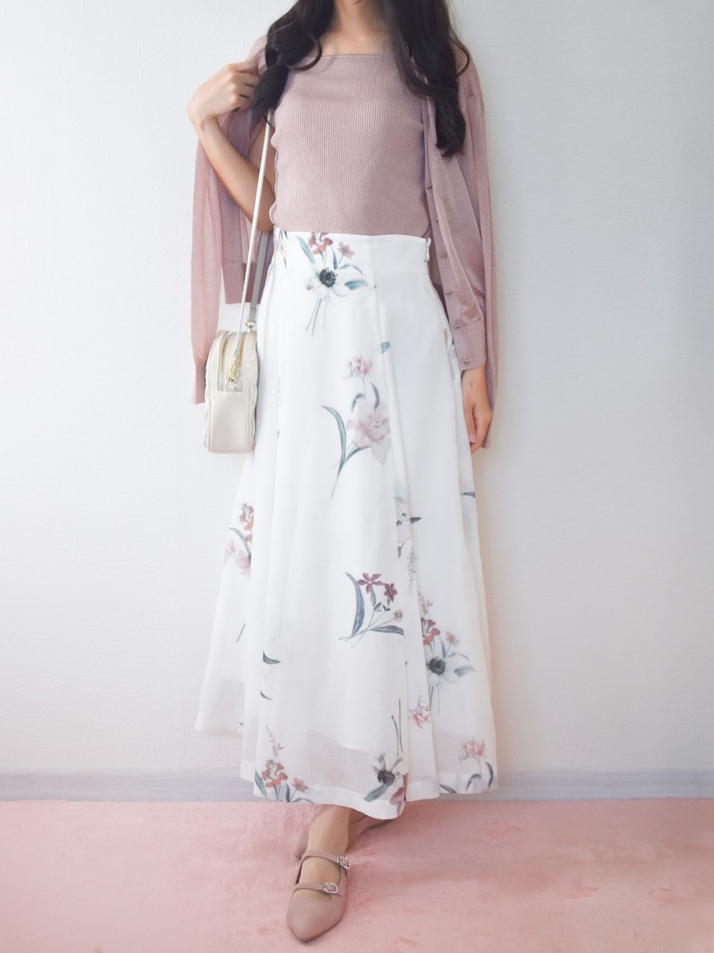 ピンク系のニット/セーター、ホワイト系のスカート、ピンク系のパンプスを着用したレディースの夏コーディネートの1枚目の写真