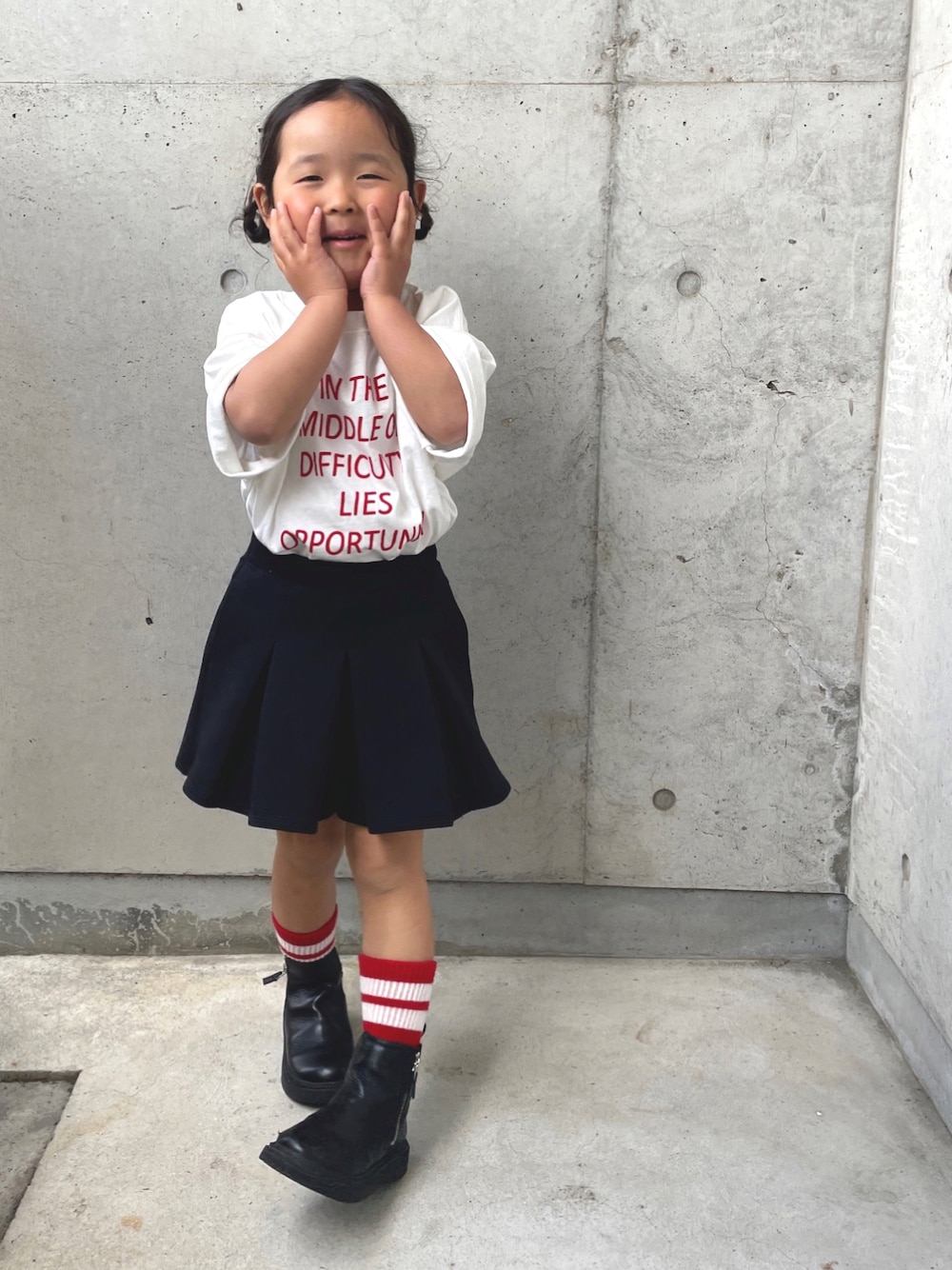 ホワイト系のTシャツ/カットソー、ブラック系のスカート、ブラック系のブーツを着用したキッズの春コーディネートの1枚目の写真