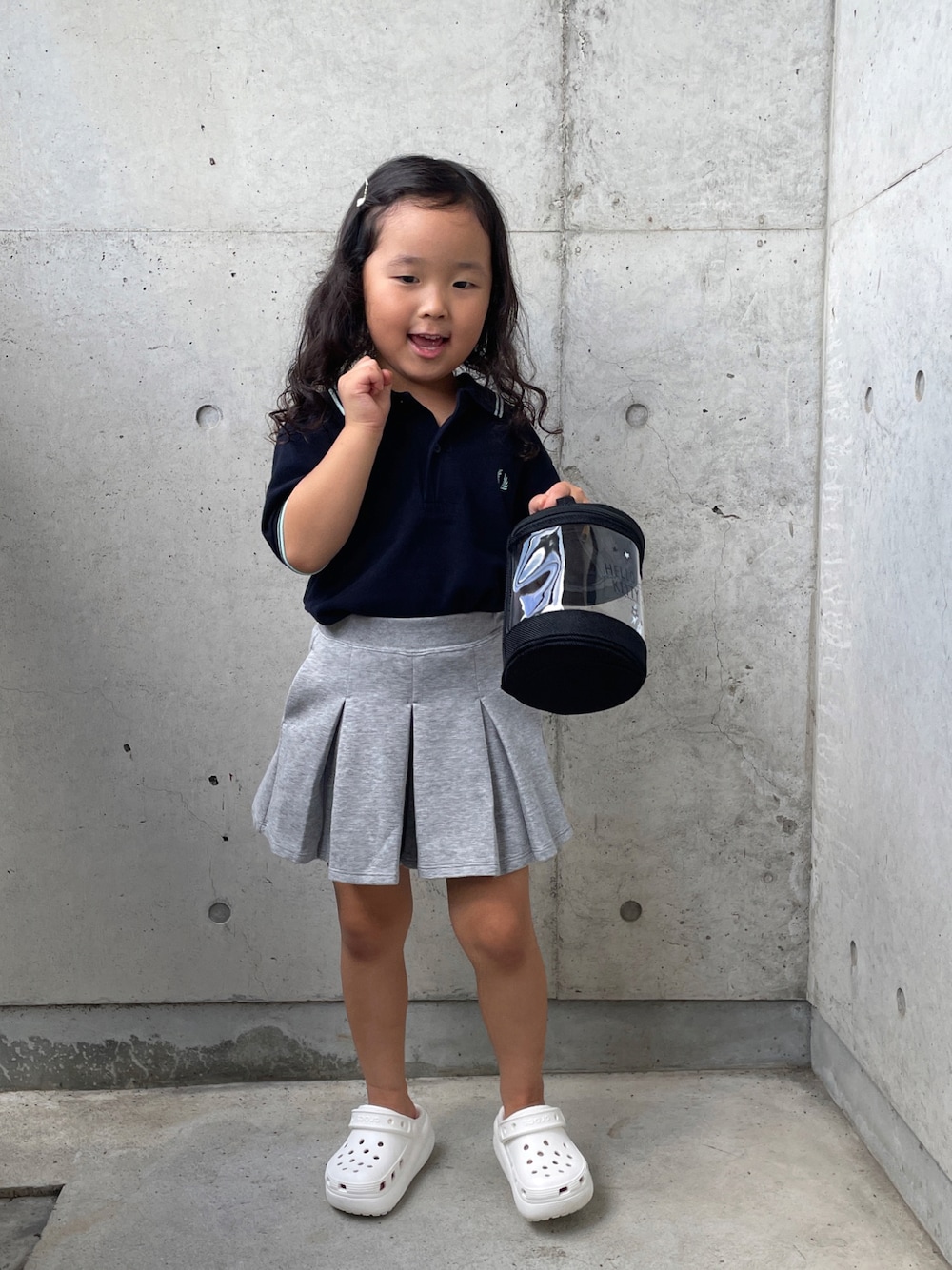ホワイト系のサンダル、ブルー系のポロシャツ、グレー系のスカートを着用したキッズの夏コーディネートの1枚目の写真