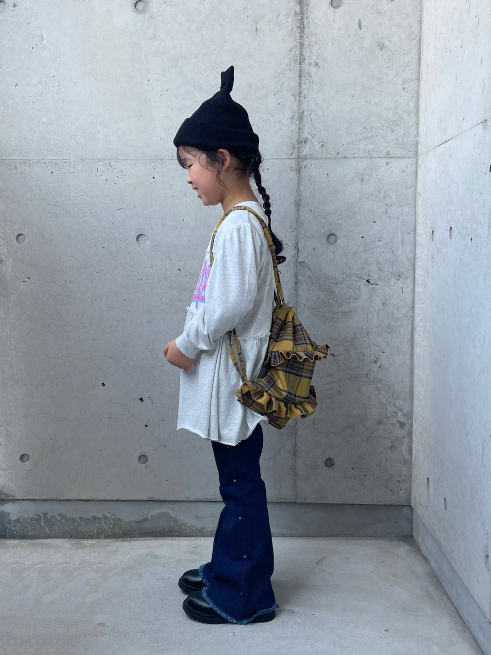 ブルー系のデニムパンツ、グレー系のワンピース、イエロー系のバックパック/リュックを着用したキッズの夏コーディネートの1枚目の写真