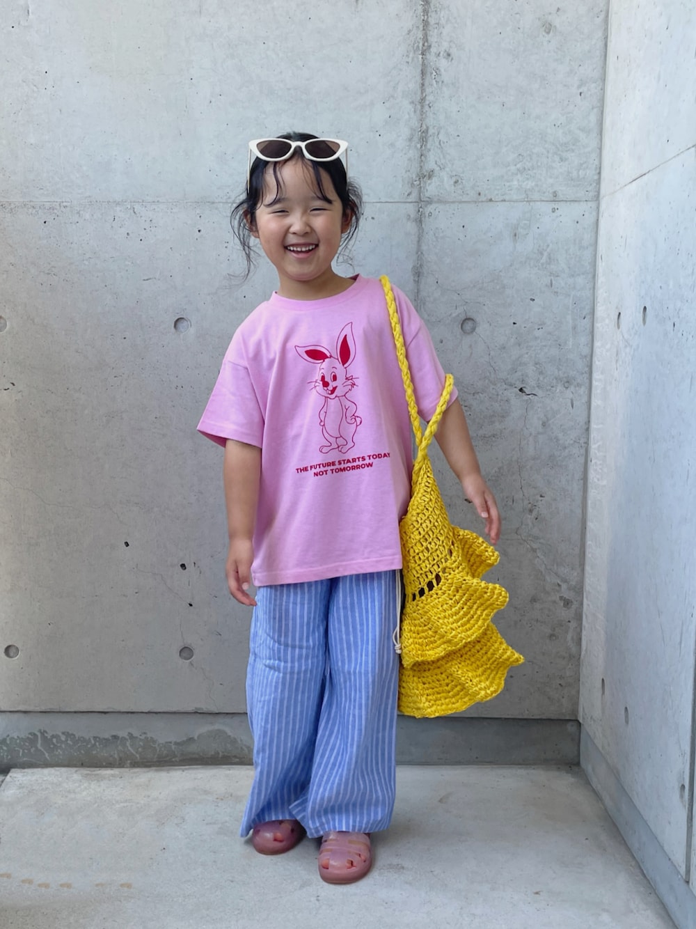 ピンク系のTシャツ/カットソー、ブルー系のパンツ、イエロー系のかごバッグを着用したキッズの夏コーディネートの1枚目の写真