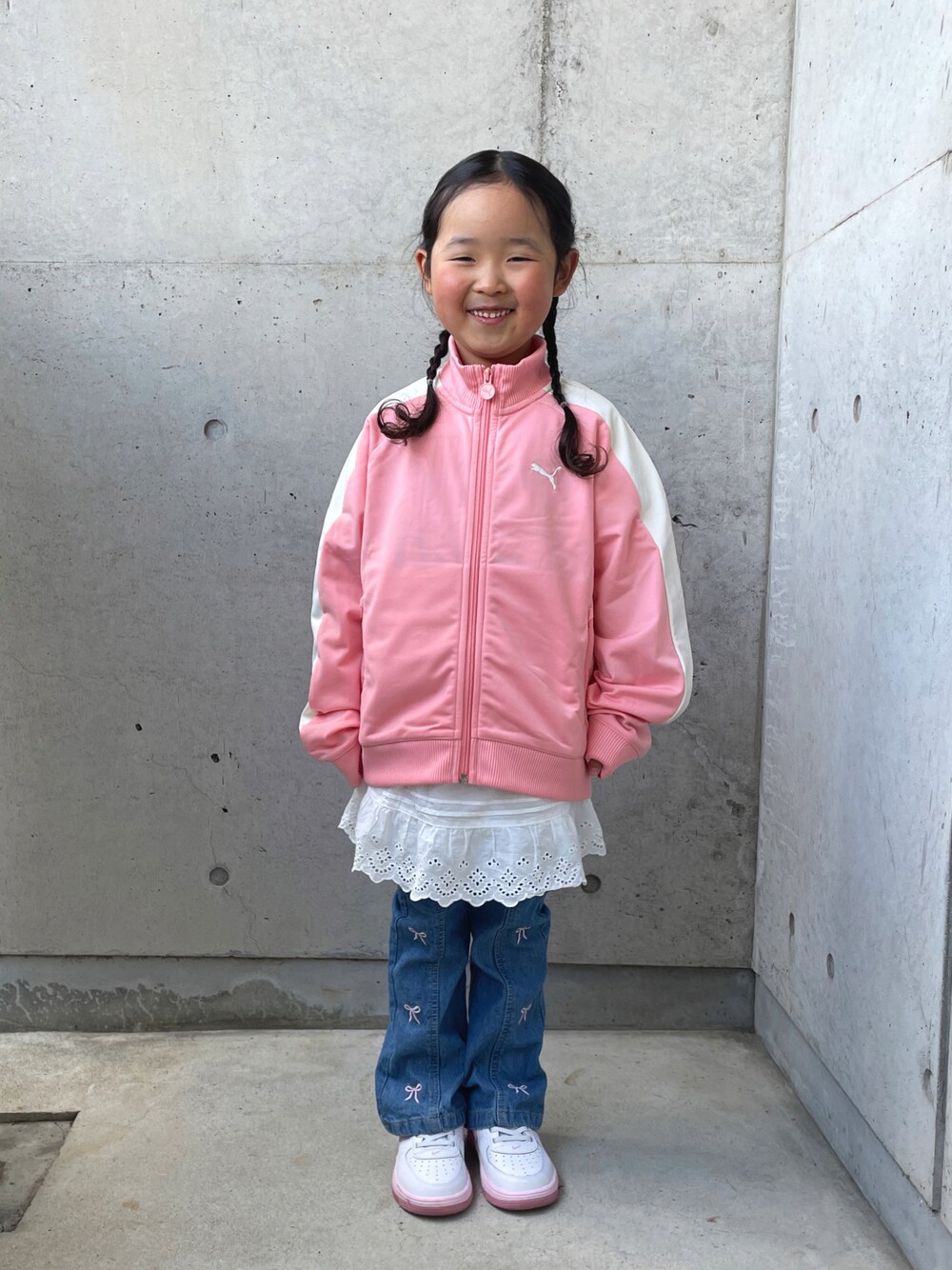 ピンク系のジャージ、ホワイト系のパンツ、ブルー系のパンツを着用したキッズの春コーディネートの1枚目の写真