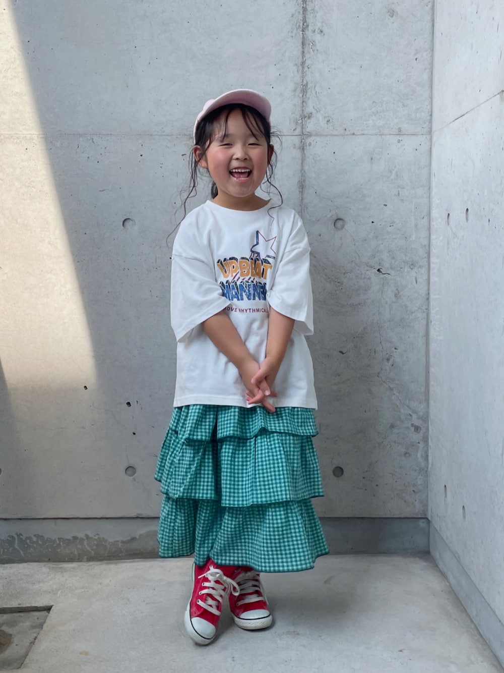 ホワイト系のTシャツ/カットソー、グリーン系のスカート、レッド系のスニーカーを着用したキッズの夏コーディネートの1枚目の写真