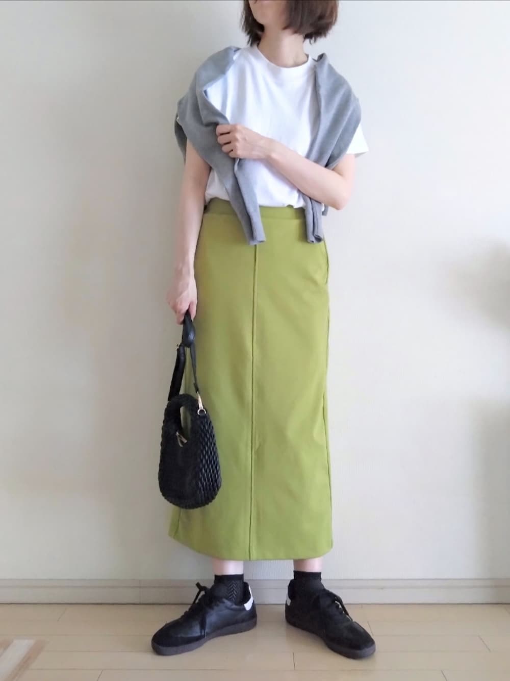 ホワイト系のTシャツ/カットソー、グレー系のカーディガン/ボレロ、グリーン系のスカートを着用したレディースの春コーディネートの1枚目の写真