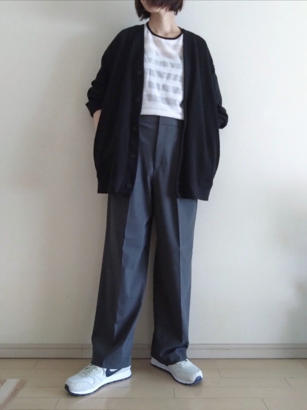 ブラック系のカーディガン/ボレロ、ホワイト系のTシャツ/カットソー、ブラック系のキャミソールを着用したレディースの春コーディネートの1枚目の写真