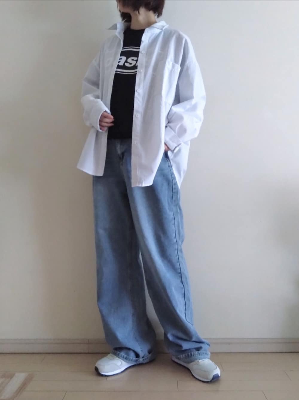 グレー系のシャツ/ブラウス、ブラック系のTシャツ/カットソー、ブルー系のデニムパンツを着用したレディースの春コーディネートの1枚目の写真