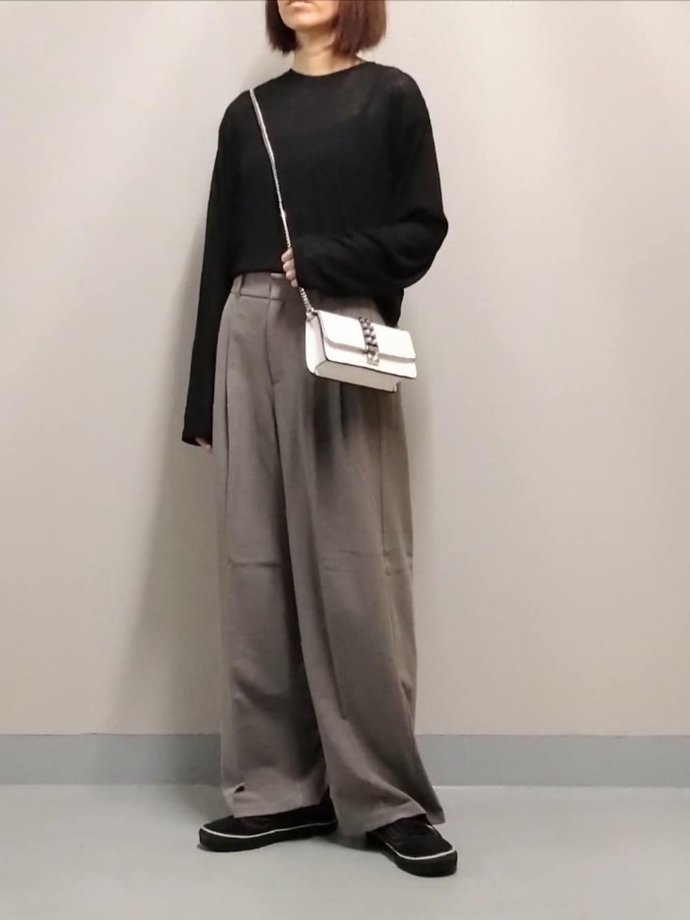 ブラウン系のスラックス、ブラック系のTシャツ/カットソー、ブラック系のキャミソールを着用したレディースの秋コーディネートの1枚目の写真