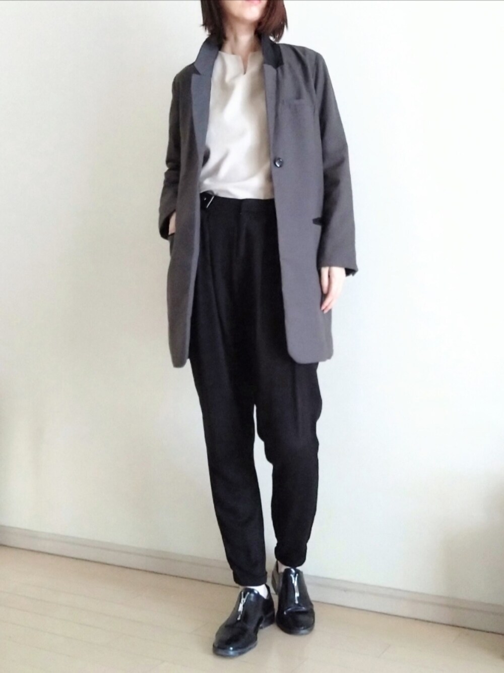 グレー系のテーラードジャケット、ベージュ系のTシャツ/カットソー、ブラック系のその他パンツを着用したレディースの秋コーディネートの1枚目の写真