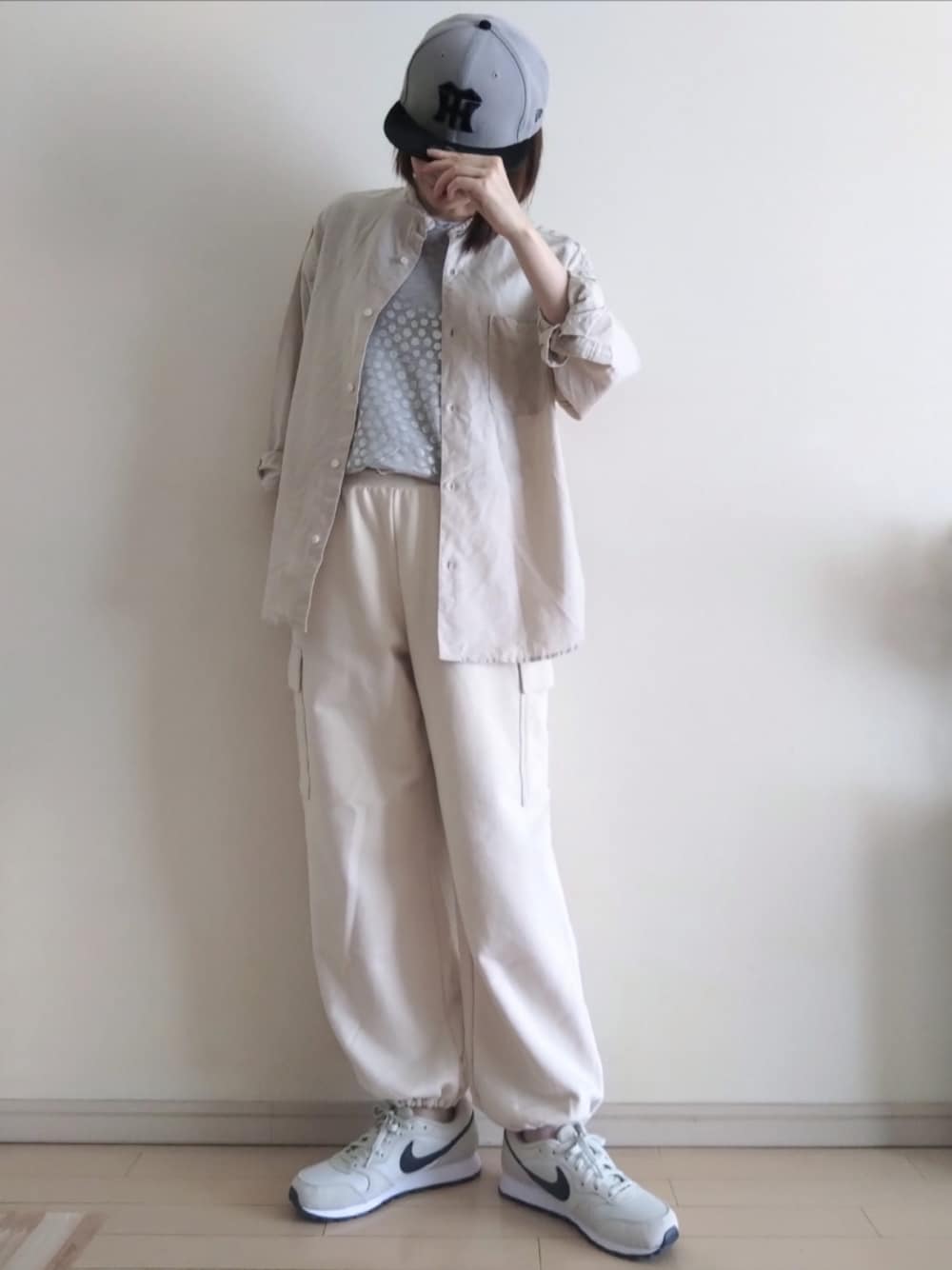 シルバー系のTシャツ/カットソー、ベージュ系のシャツ/ブラウス、ホワイト系のカーゴパンツを着用したレディースの春コーディネートの1枚目の写真
