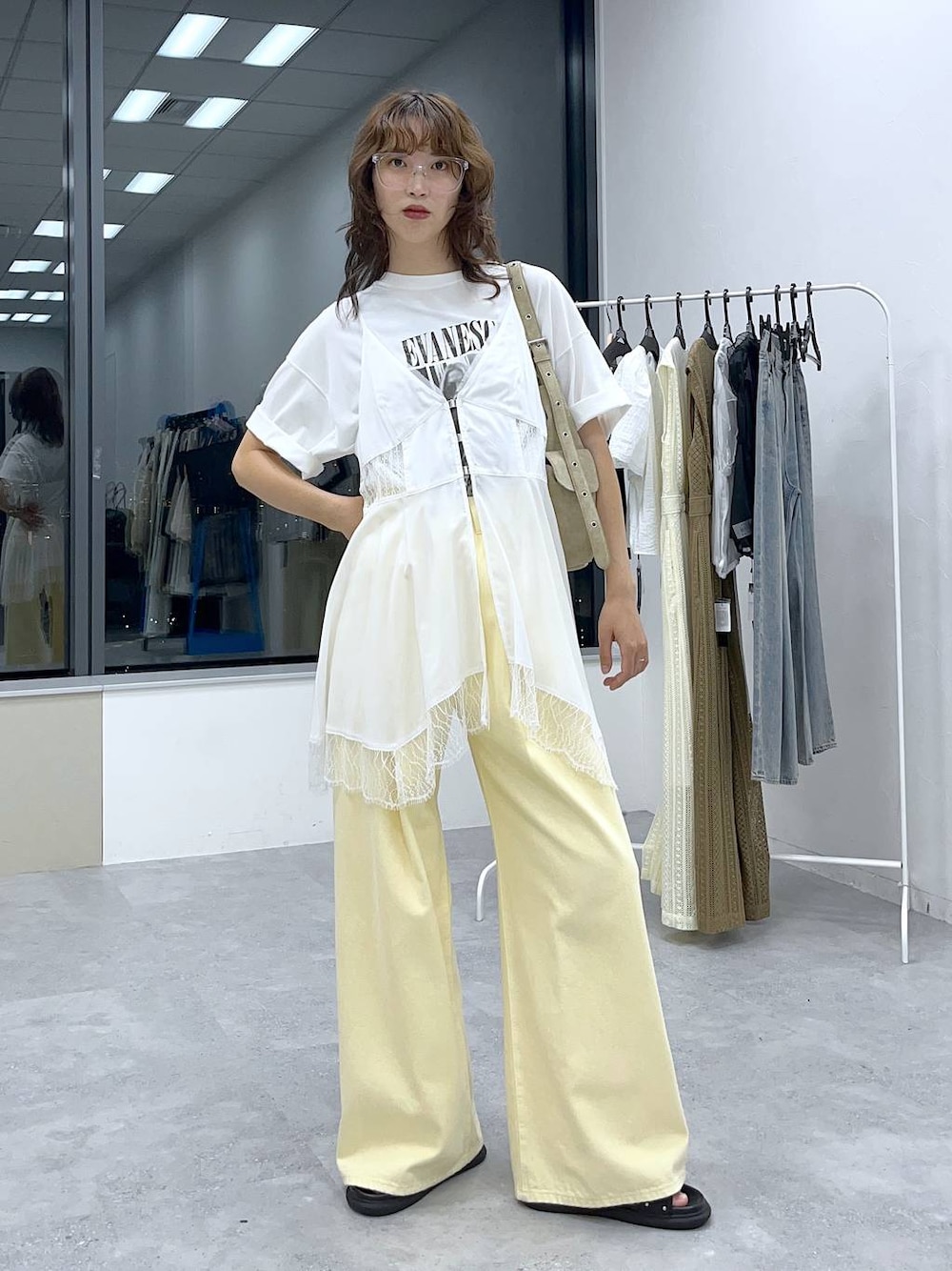 イエロー系のデニムパンツ、ホワイト系のキャミソール、ホワイト系のTシャツ/カットソーを着用したレディースの夏コーディネートの1枚目の写真