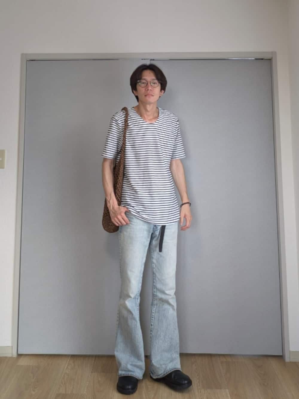 ホワイト系のTシャツ/カットソー、ブルー系のデニムパンツ、ブラック系のサンダルを着用したメンズの夏コーディネートの1枚目の写真