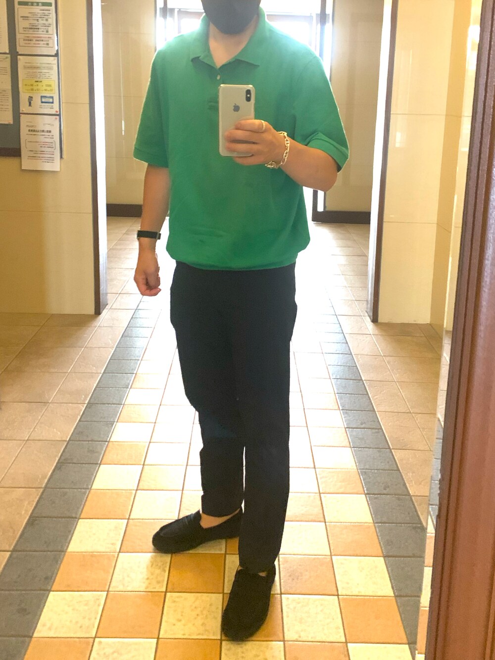 ブルー系のスラックス、ブラック系のサンダル、グリーン系のポロシャツを着用したメンズの夏コーディネートの1枚目の写真