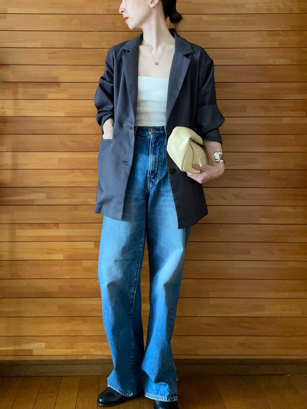 グレー系のテーラードジャケット、ホワイト系のキャミソール、ブルー系のデニムパンツを着用したレディースの夏コーディネートの1枚目の写真