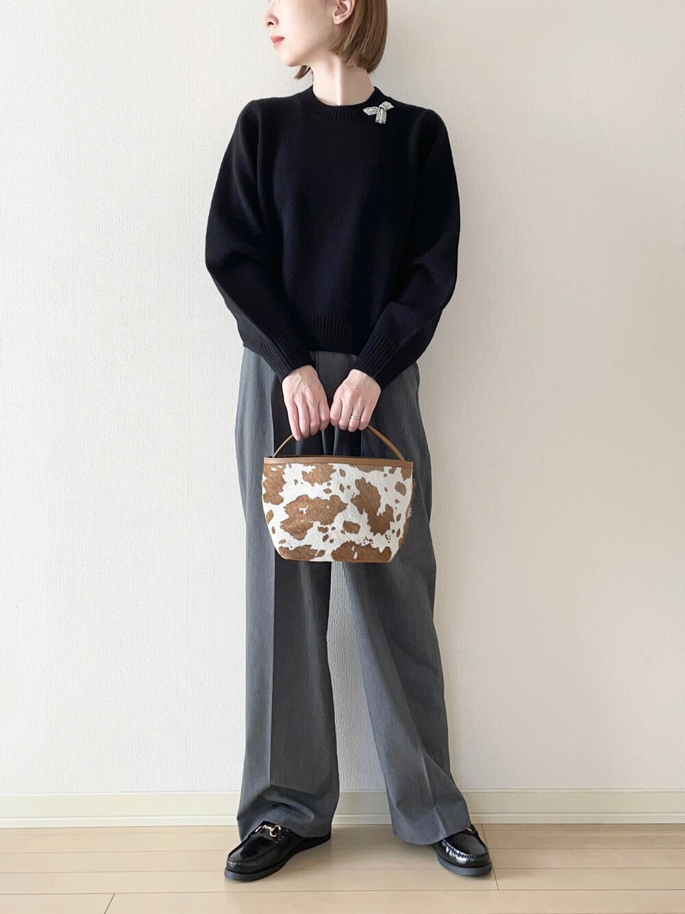 ブラック系のニット/セーター、グレー系のその他パンツ、ブラック系のローファーを着用したレディースの秋コーディネートの1枚目の写真