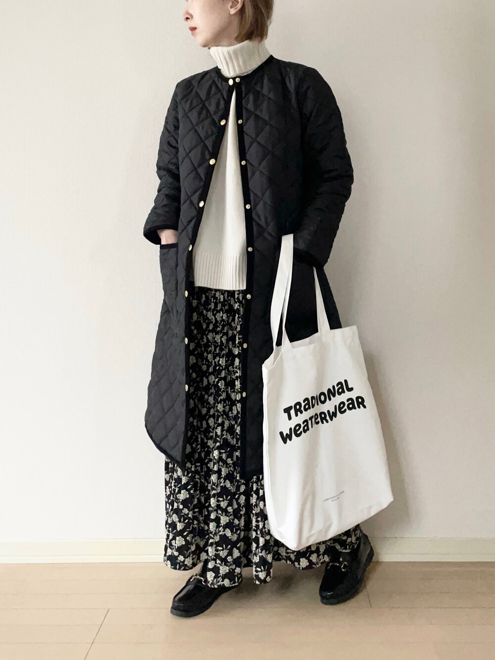 「Traditional Weatherwear、トラディショナルウェザーウェア、TWW、キルティングジャケット、タートルネックニット、花柄スカート、ローファー、トートバッグ、大人カジュアル、オトナカジュアル、冬コーデ、モノトーン」｜「Traditional WeatherwearのARKLEY LONG（その他アウター、ブラック系）」を使った、𝐀𝐍𝐘さん（レディース・156cm）の冬コーディネートの1枚目の写真