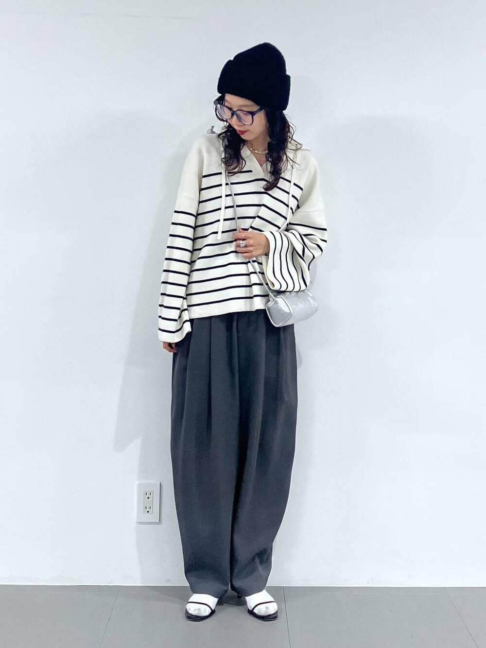 シルバー系のショルダーバッグ、グレー系のその他パンツ、ホワイト系のニット/セーターを着用したレディースの冬コーディネートの1枚目の写真