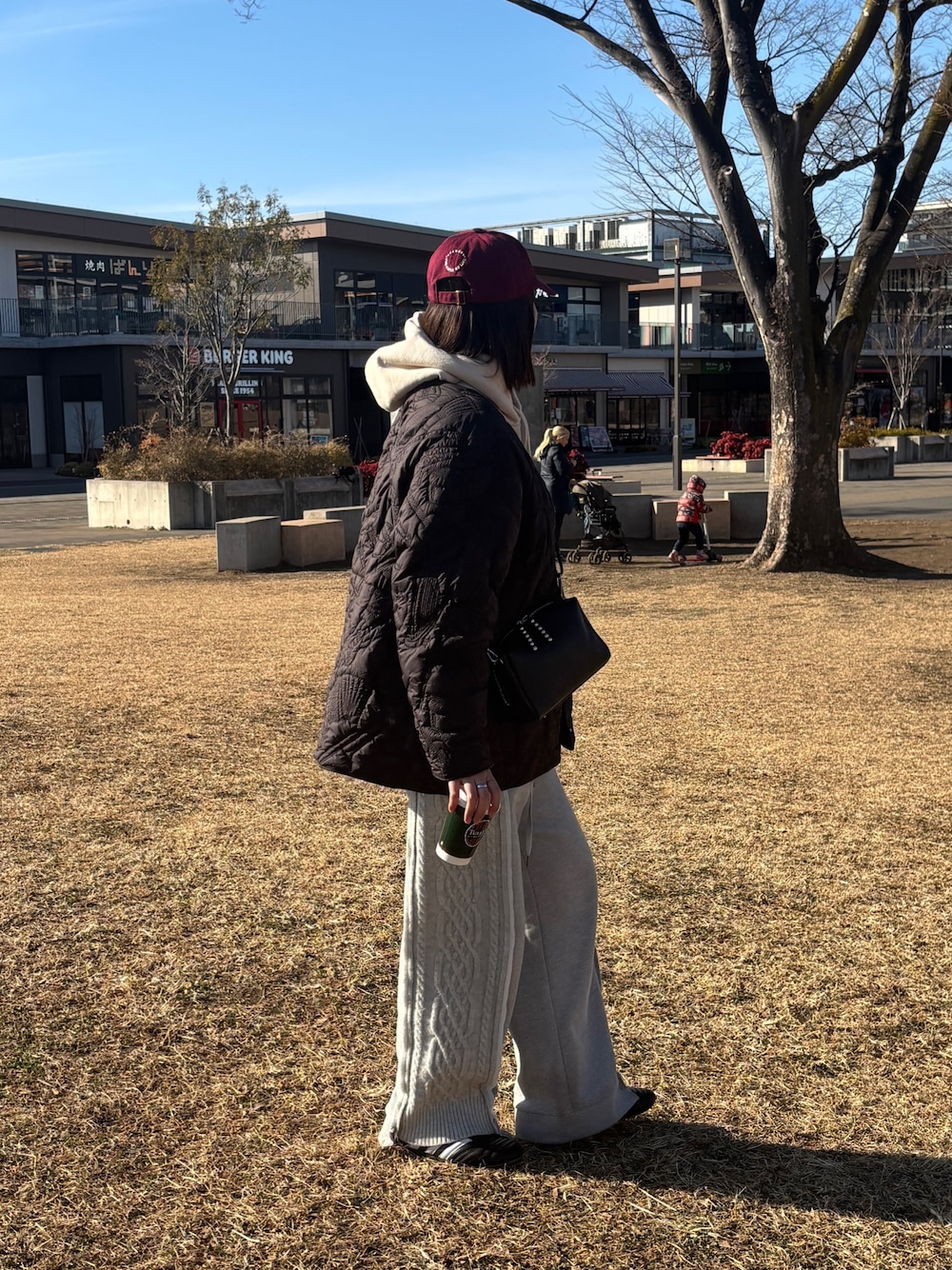 ブラック系のショルダーバッグ、グレー系のその他パンツ、ブラック系のその他アウターを着用したレディースの冬コーディネートの1枚目の写真